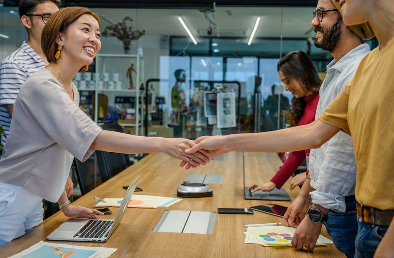 Il_Commento_di_John_Leguizamo_AMu7g8WXRH - Confidenze24 Source: Ketut Subiyanto - pexels - A diverse team of smiling professionals shaking hands during a productive meeting in a modern office.