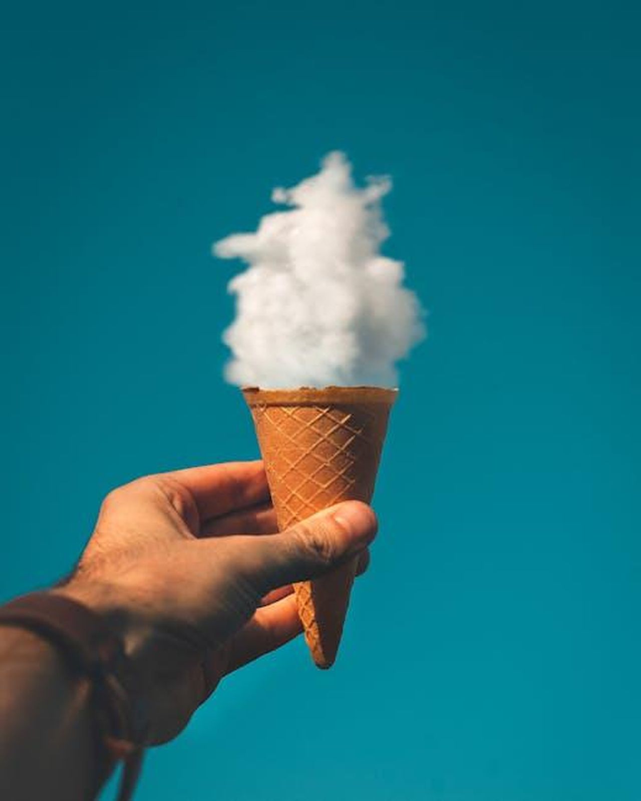 Il_Covid_ha_risvegliato_la_mia_creativit_UwAYNHIVYf - Confidenze24 Source: Rakicevic Nenad - pexels - Hand holding an ice cream cone with a cloud effect against a clear sky background.