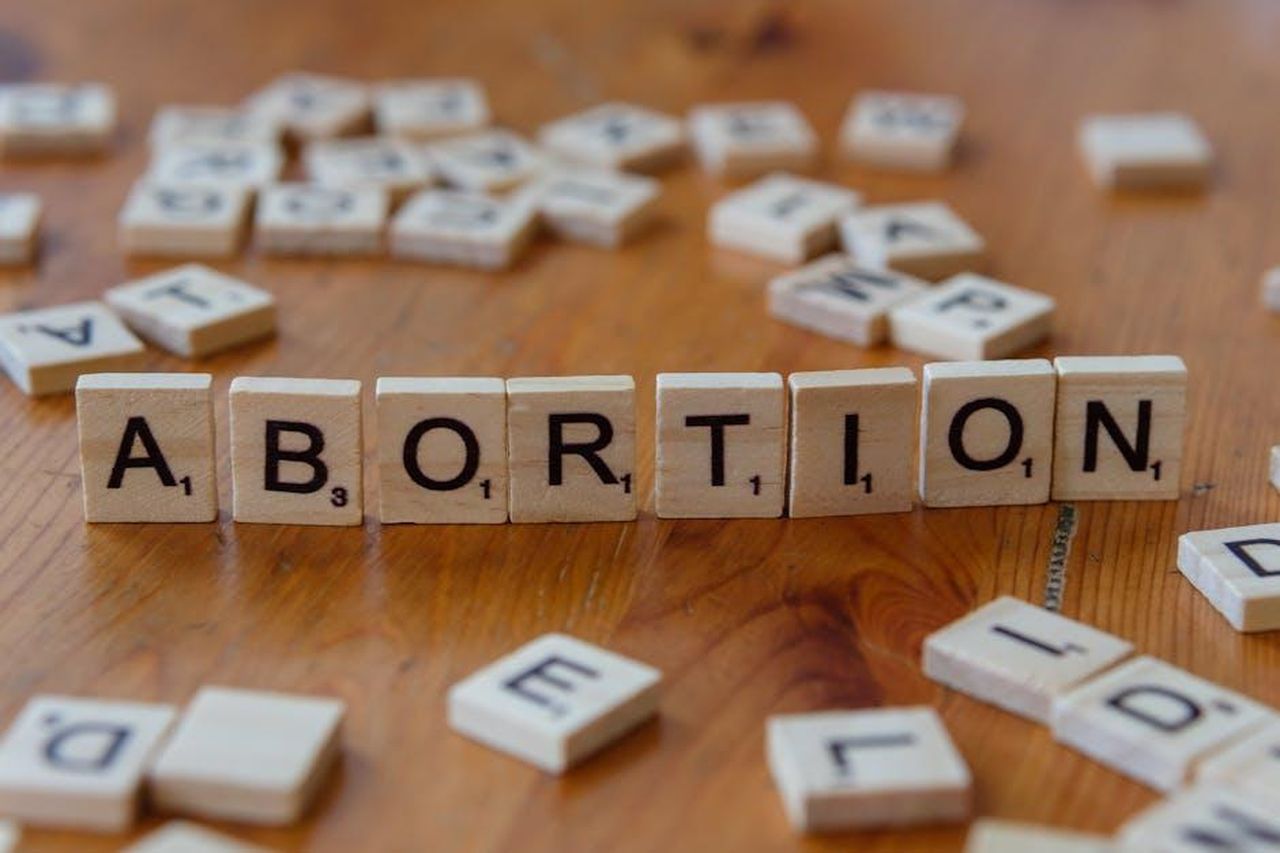 Il_Dilemma_Morale_di_Mark_S_nella_Stagione_3_5Sl7ycRus8 - Confidenze24 Source: Markus Winkler - pexels - Scrabble tiles spelling 'abortion', highlighting the debate on reproductive rights.