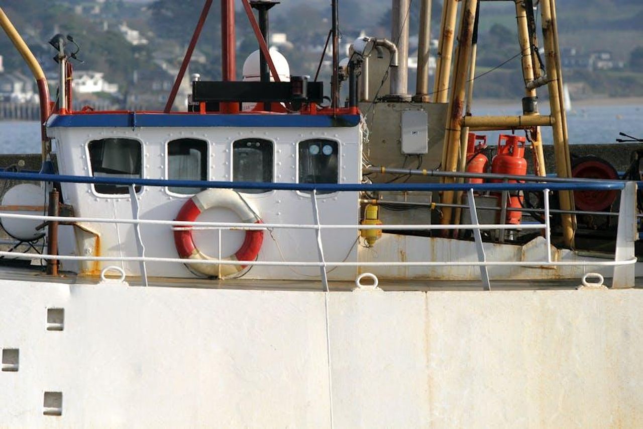 Il_Duchy_of_Cornwall_e_la_sua_importanza_l7Lyhd7JR9 - Confidenze24 Source: Paul Groom Photography Bristol - pexels - Close-up of a fishing boat docked in Padstow Harbour, featuring nautical details and vibrant colors.