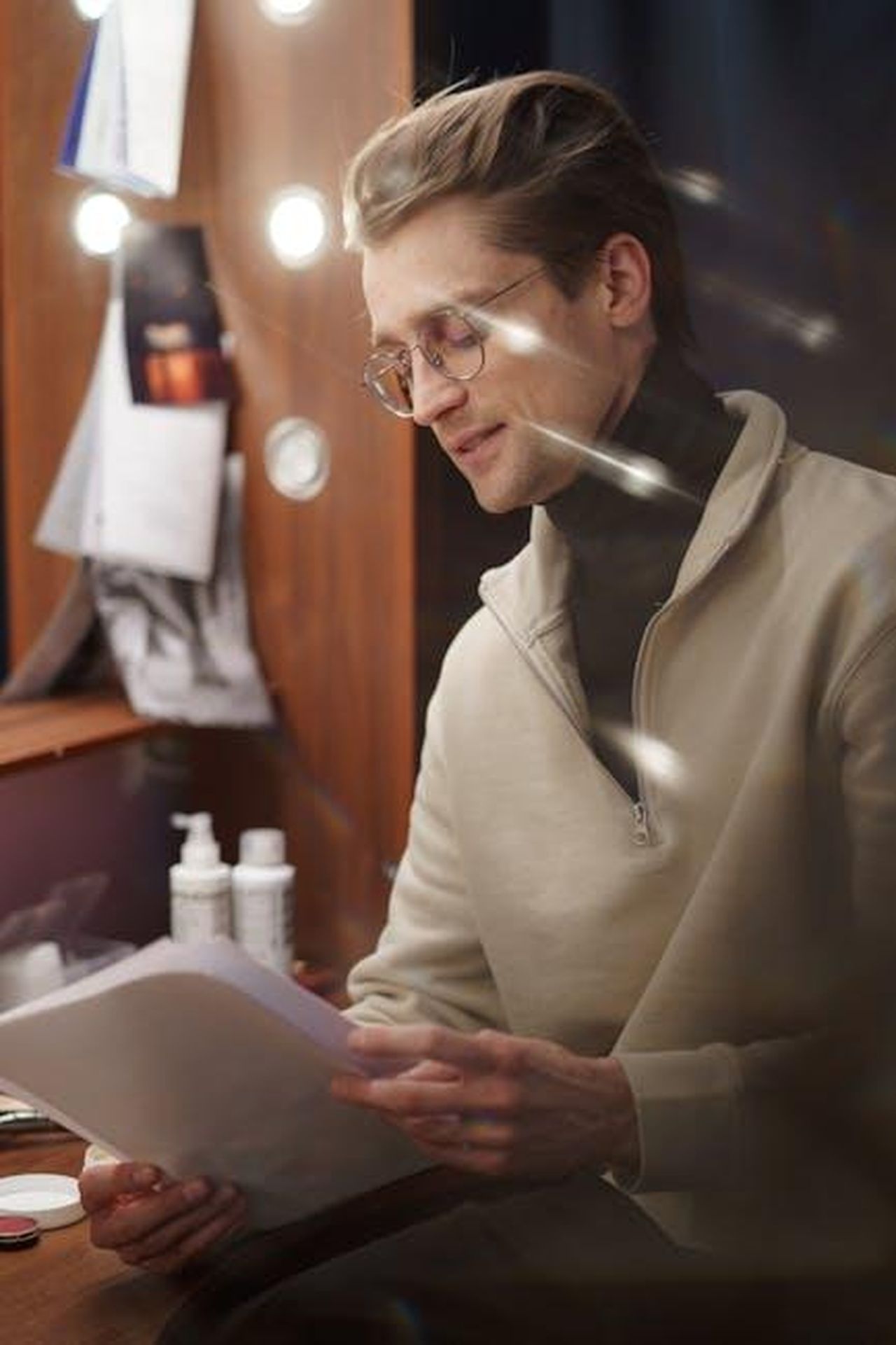 Il_Personaggio_di_Milchick_e_le_Sorprese_della_Stagione_3_UAuJDMR2IL - Confidenze24 Source: cottonbro studio - pexels - A man reading a script backstage in a dressing room, possibly preparing for a theater performance.