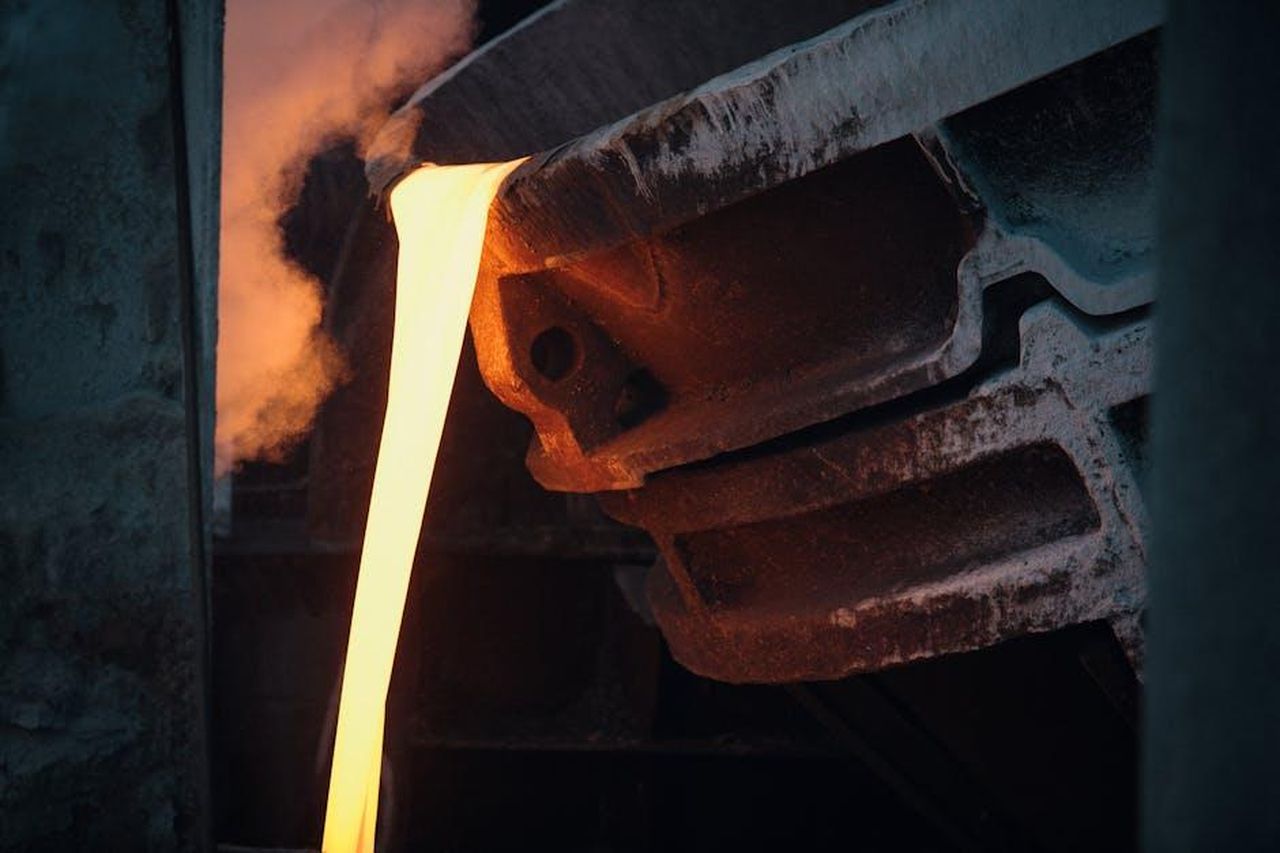 Il_Processo_di_Casting_e_la_Visione_di_Paul_Williams_Davies_5MHrSUbwOe - Confidenze24 Source: Bence Szemerey - pexels - Molten metal pouring from ladle in industrial foundry, capturing the intense heat and energy.
