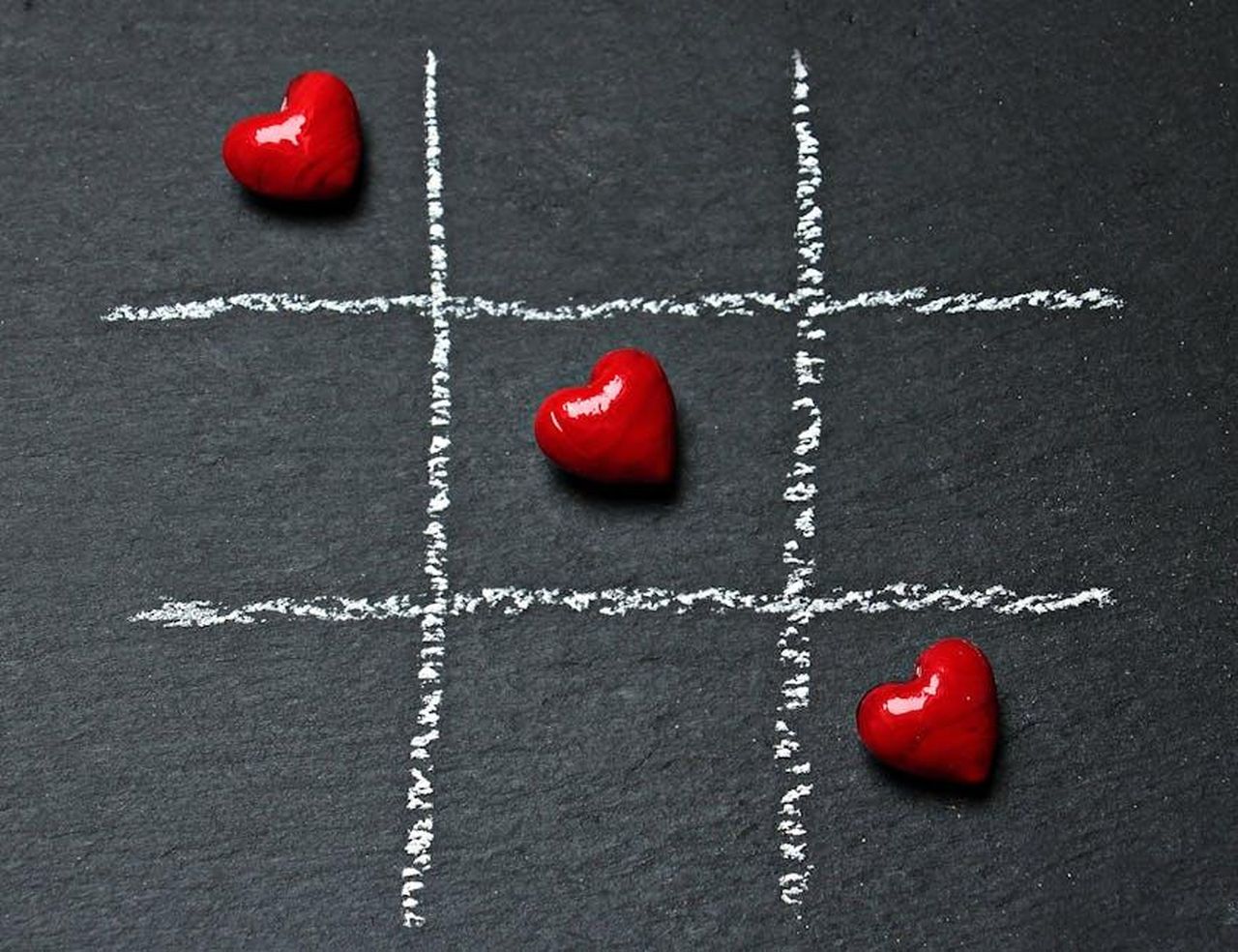 Il_Rapporto_tra_Vanna_e_Ryan_Seacrest_AX1CYRTDRe - Confidenze24 Source: Pixabay - pexels - Tic tac toe board on black surface with red heart shapes symbolizing love and connection.