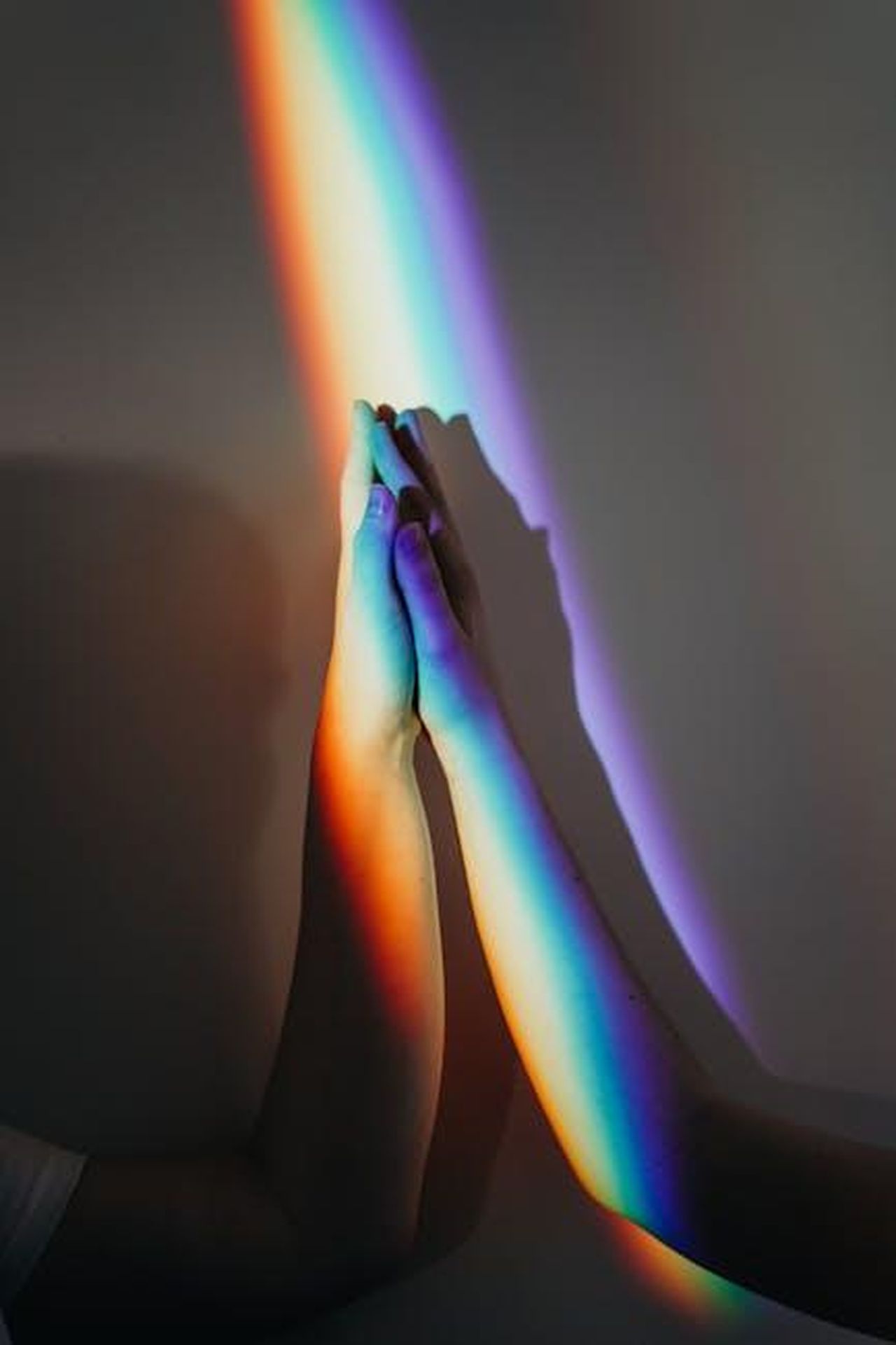 Il_Ruolo_di_Faith_Hill_nel_Percorso_di_Recupero_EkCzoyMj1s - Confidenze24 Source: cottonbro studio - pexels - Two diverse hands touch under a rainbow light symbolizing unity and diversity.