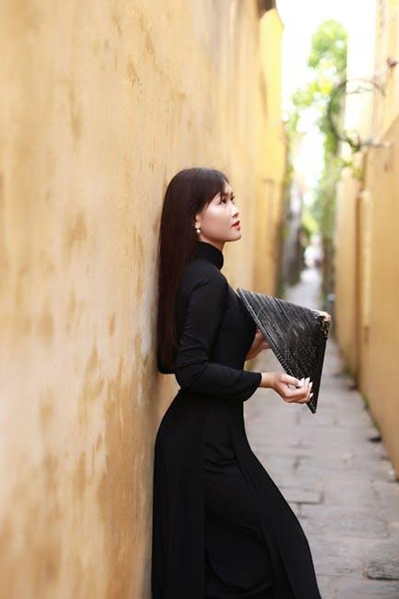 Il_Successo_di_Tracker_e_il_Rinnovo_per_la_Terza_Stagione_ebrOS4ZzTm - Confidenze24 Source: Võ Văn Tiến - pexels - Woman in black Ao Dai holding fan in historic Hoi An alleyway.