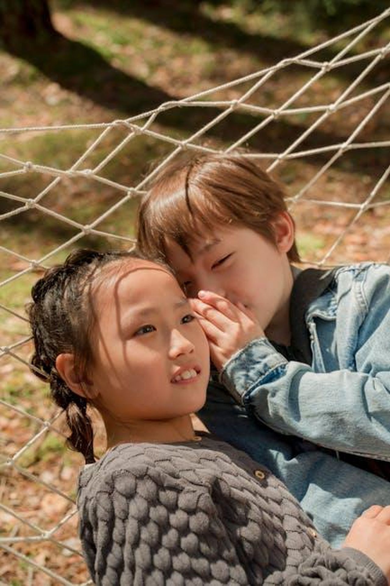 Il_Tema_dei_Segreti_Familiari_nella_Stagione_2_Qb0eRwwywe - Confidenze24 Source: Ron Lach - pexels - Two children sharing secrets while lying on a hammock in the sunny outdoors.