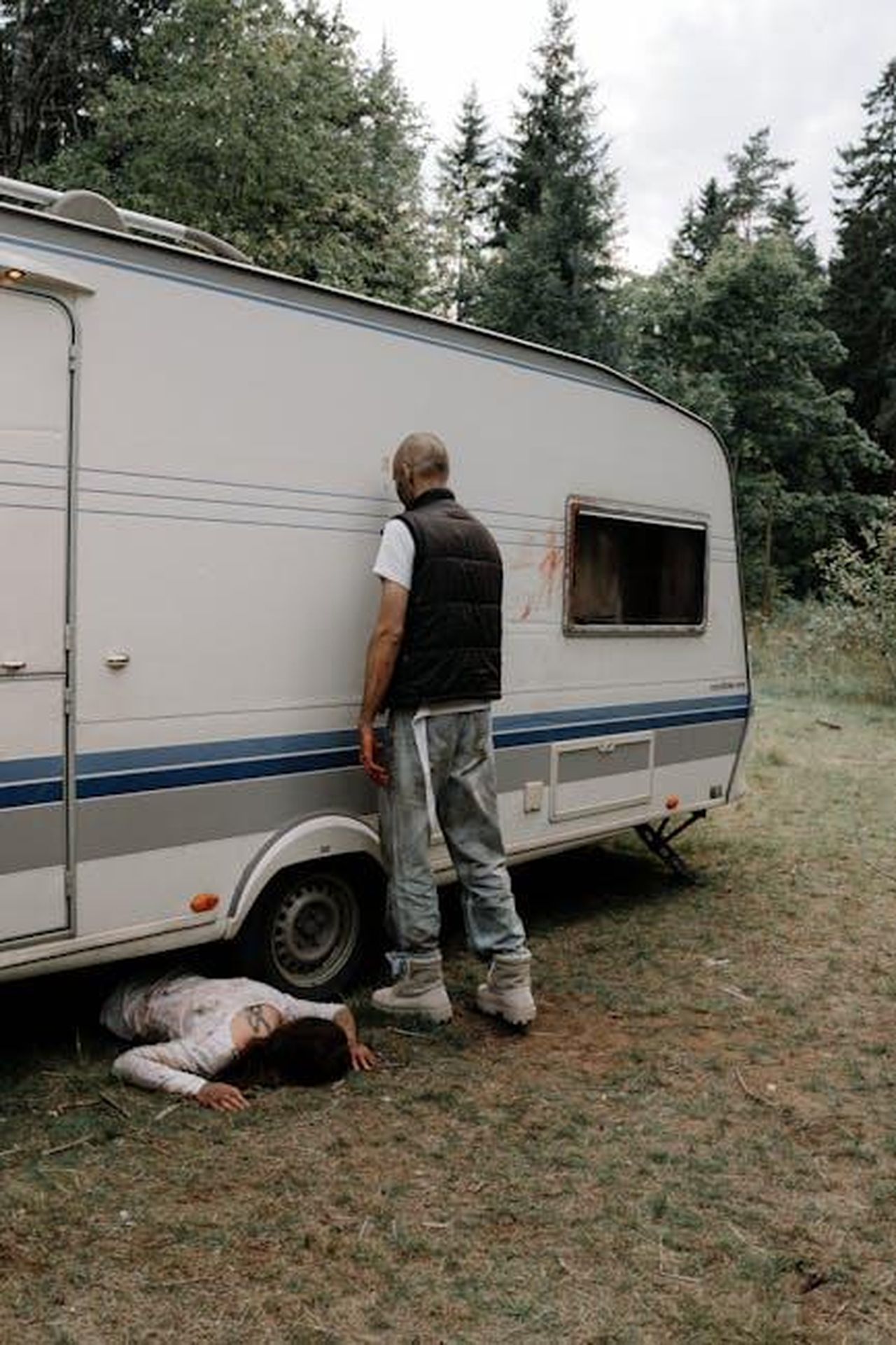 Il_Trailer_Rivela_Dettagli_Sospetti_Ez513Fn1aa - Confidenze24 Source: cottonbro studio - pexels - A haunting scene with a figure leaning on a camper, evoking horror themes.