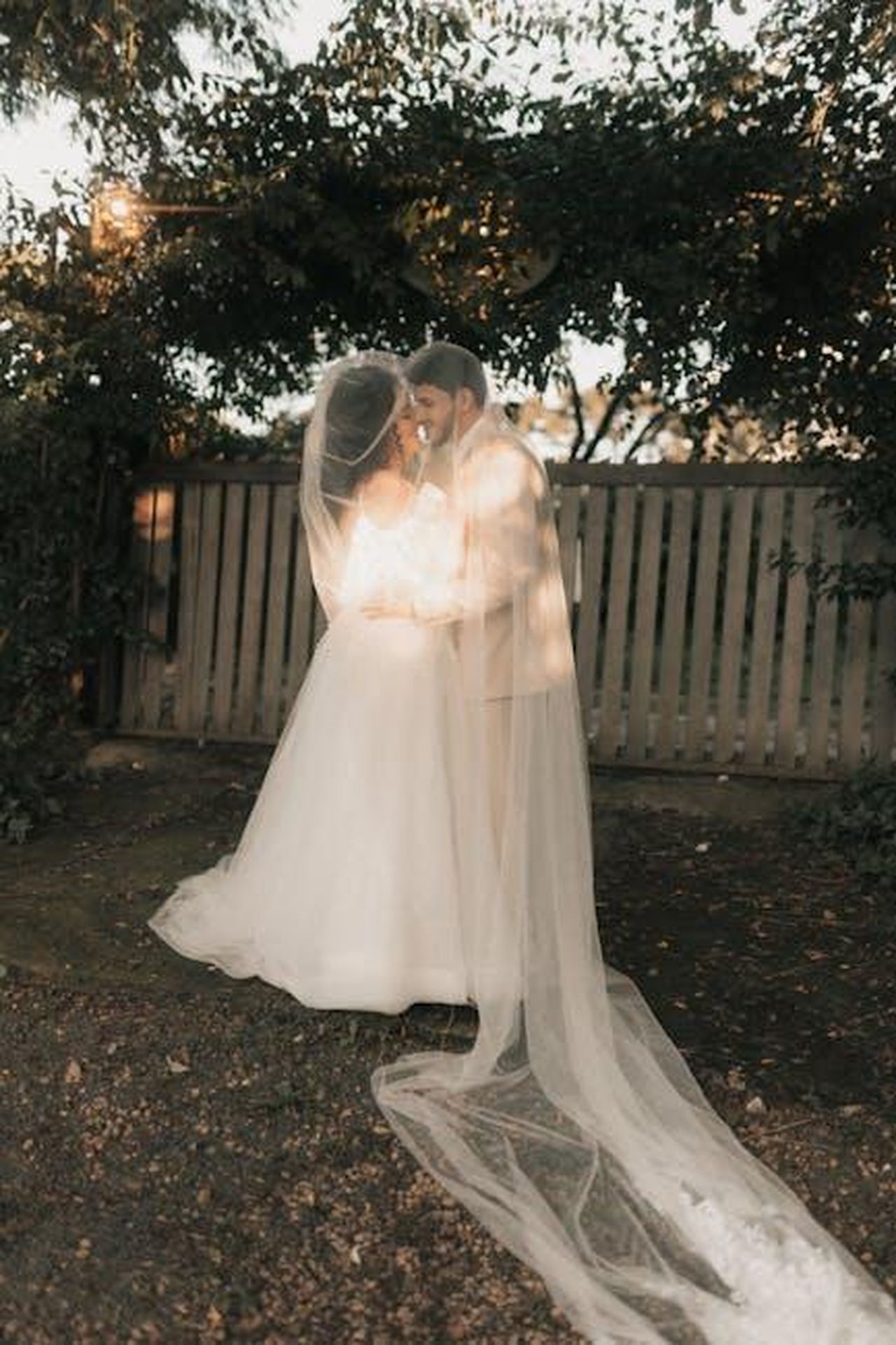 Il_bacio_tra_Danny_Jones_e_Maura_Higgins_ai_BRITs_sxSj2wwQAK - Confidenze24 Source: Alexander Mass - pexels - Bride and groom share a romantic kiss outdoors at twilight under the trees.