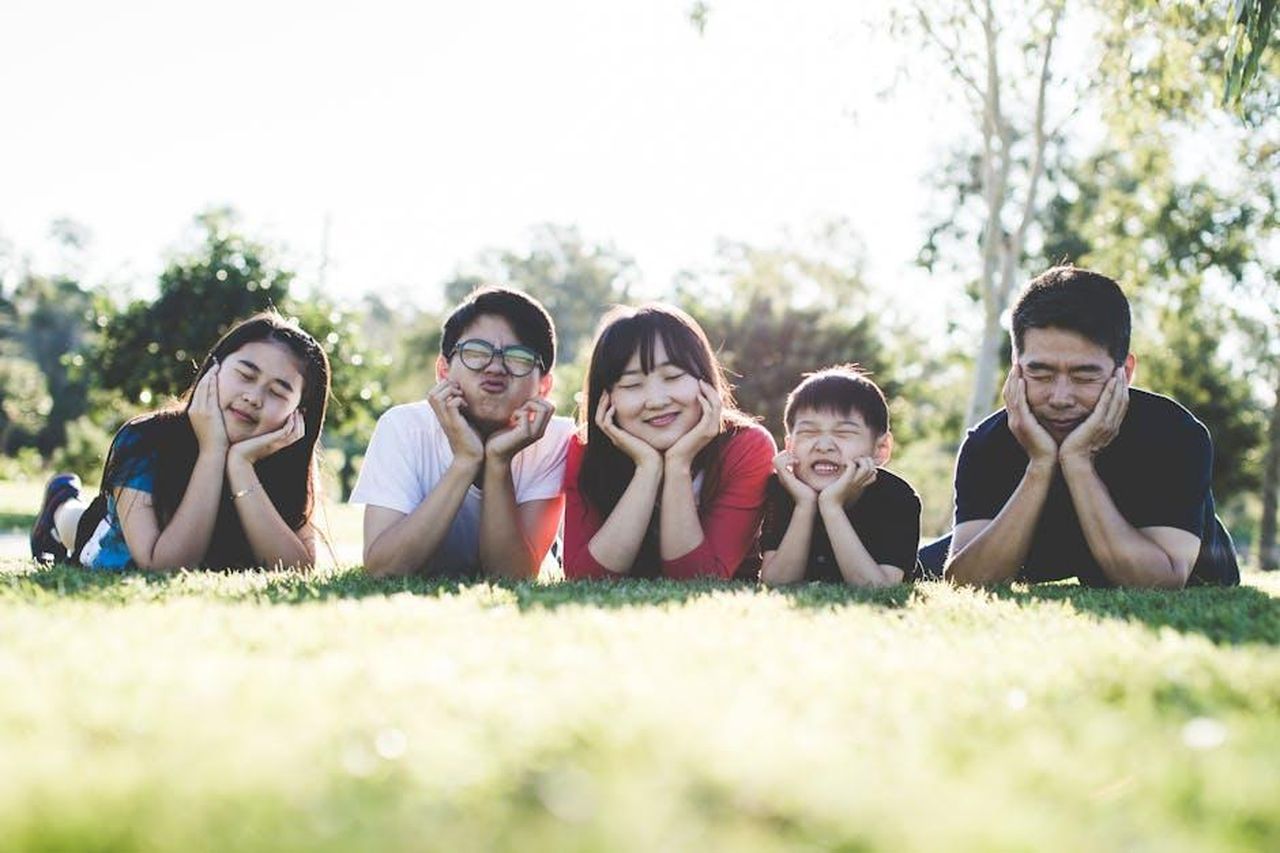 Il_cognome_Sussex_KdF3EyAAtE - Confidenze24 Source: Pixabay - pexels - Asian family posing happily on the grass in a sunny park, showcasing love and togetherness.