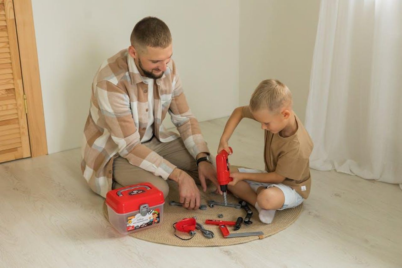 Il_contesto_familiare_e_le_difficolt_economiche_N93lwN2cQU - Confidenze24 Source: Polesie Toys - pexels - Father and son enjoying quality time assembling toys indoors, fostering creativity.