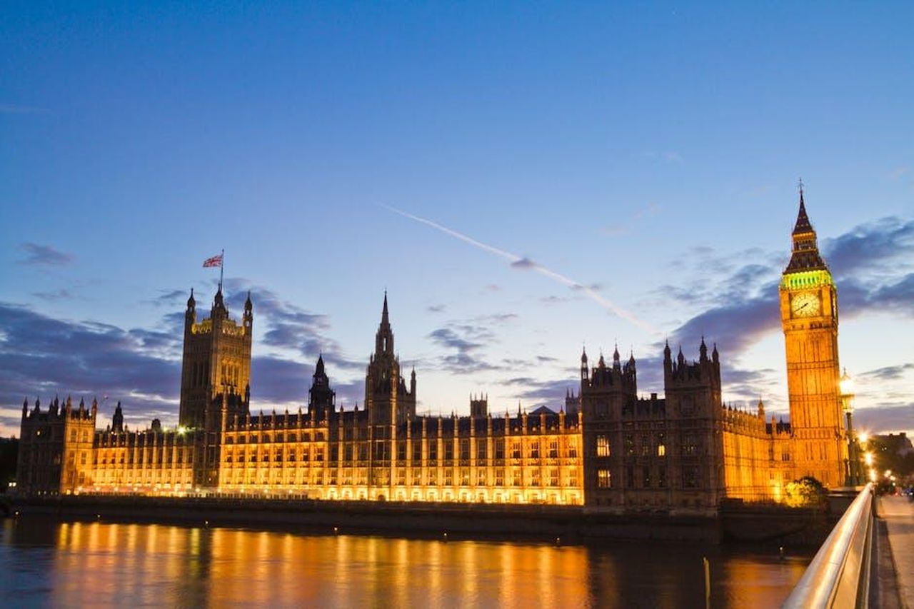Il_contesto_politico_e_le_reazioni_Qm1rui286P - Confidenze24 Source: Michael D Beckwith - pexels - The Palace of Westminster and Big Ben illuminated at dusk along the River Thames in London.