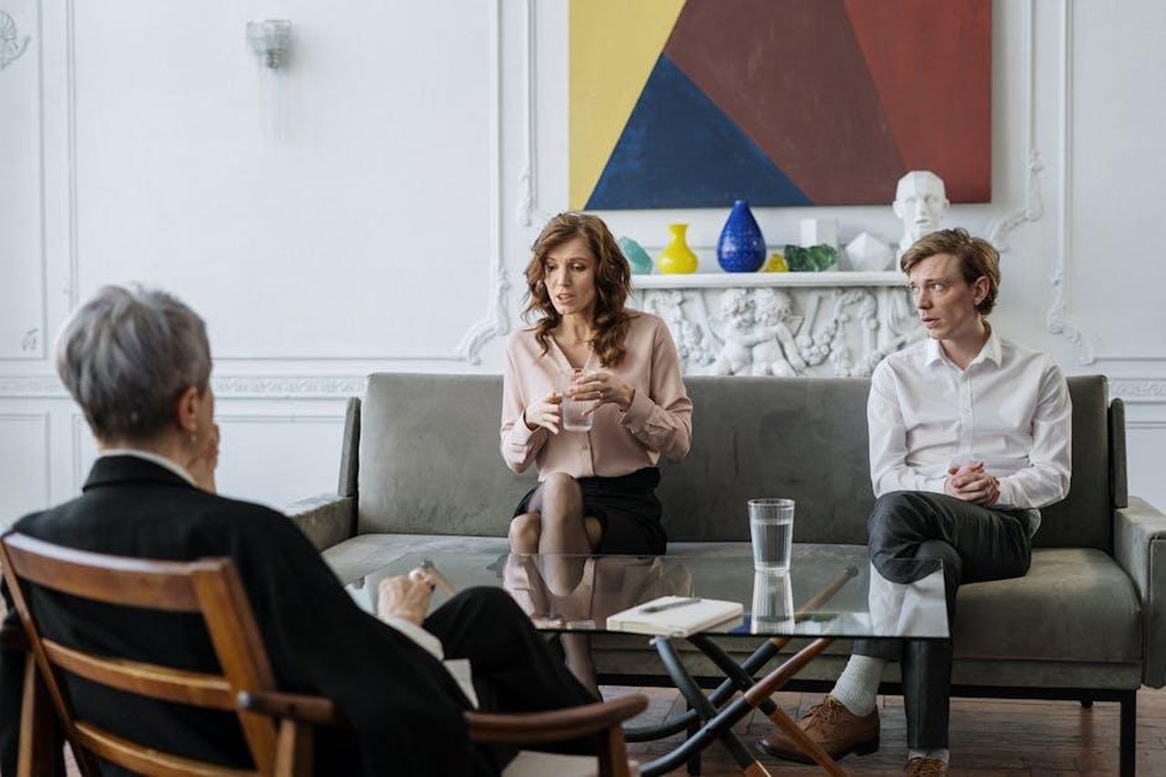 Il_divorzio_di_Costner_da_Cindy_Silva_Vw35ByBjq4 - Confidenze24 Source: cottonbro studio - pexels - A couple conversing with a therapist in a chic, modern office setting.