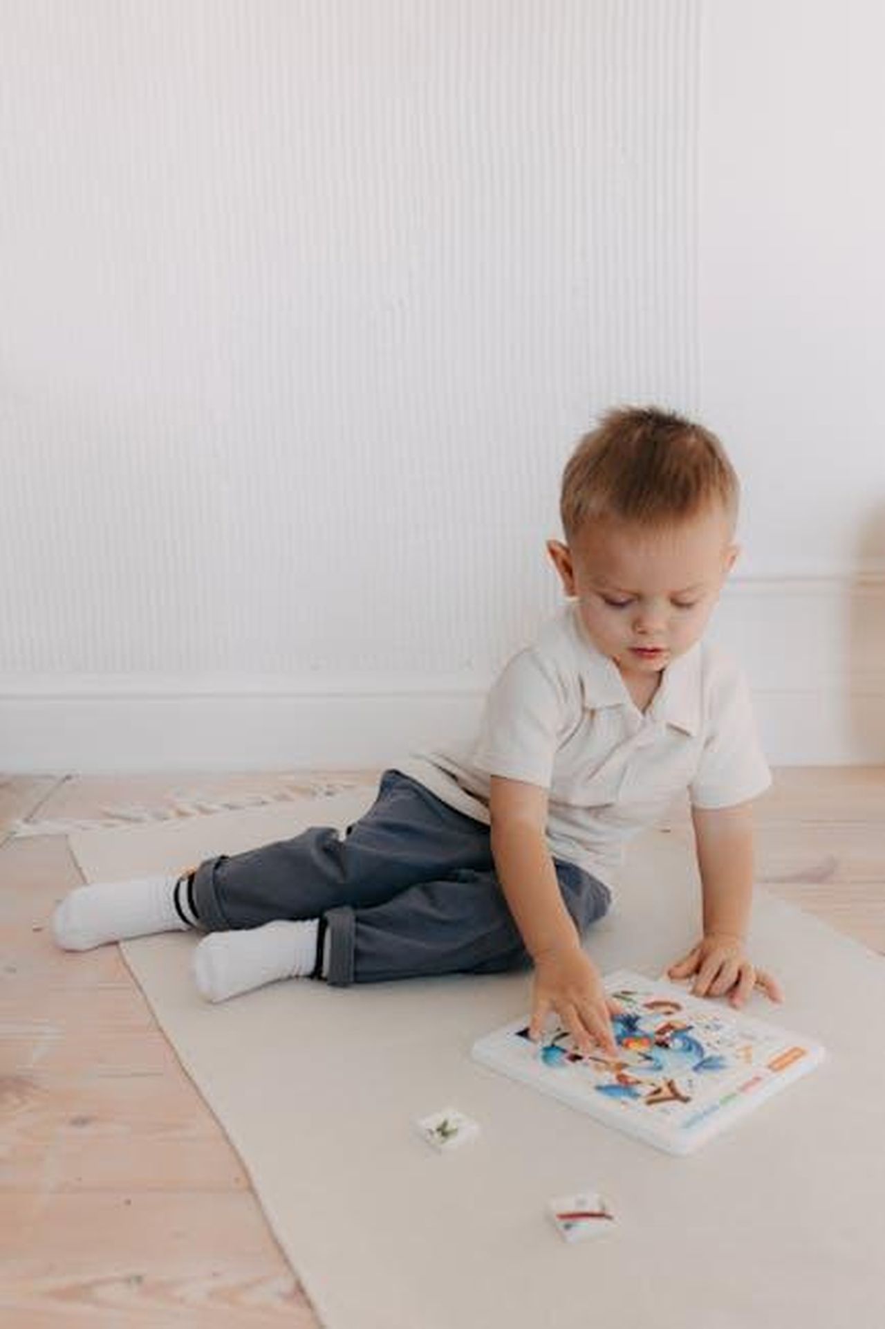 Il_documentario_Make_It_Look_Real_bMcQP24I0O - Confidenze24 Source: Polesie Toys - pexels - A young boy intently exploring a colorful picture book while seated on a rug indoors.
