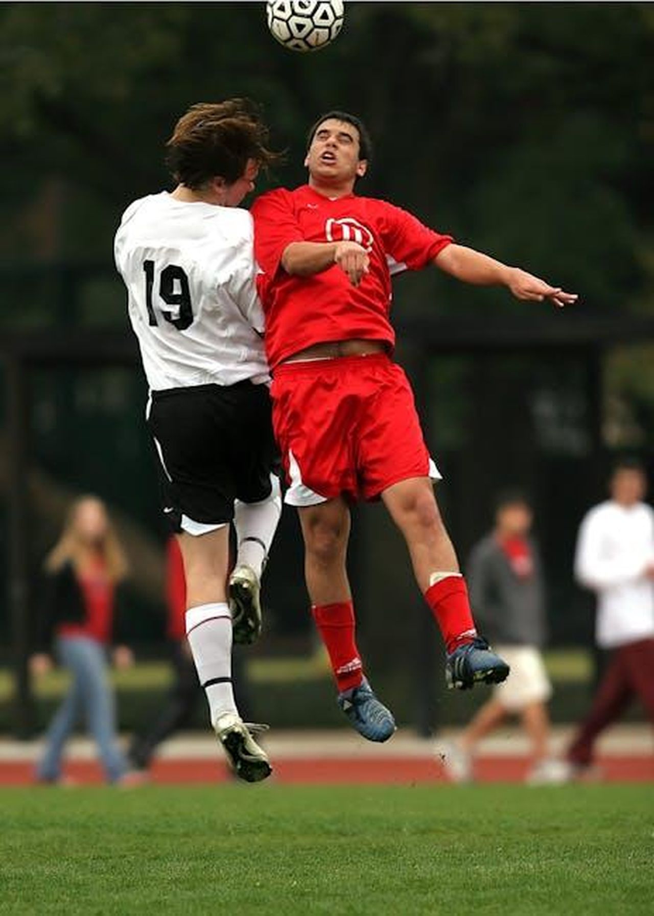 Il_finale_della_battaglia_verbale_KTkOwoSBiI - Confidenze24 Source: Pixabay - pexels - Two soccer players in mid-air challenge on a green field during a game.