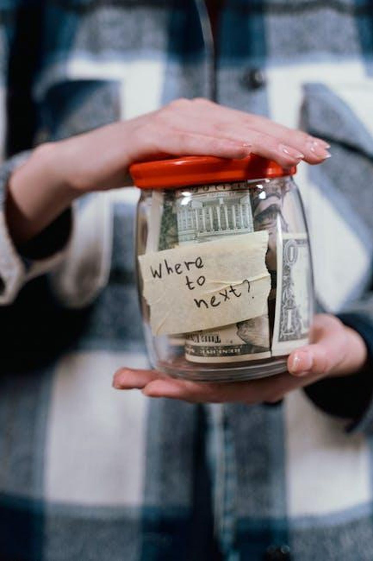Il_futuro_di_Eva_Longoria_riflessioni_e_obiettivi_Lo44ROr1O8 - Confidenze24 Source: Tima Miroshnichenko - pexels - A person holds a savings jar filled with money and a note that says 'Where to next?' symbolizing travel savings.