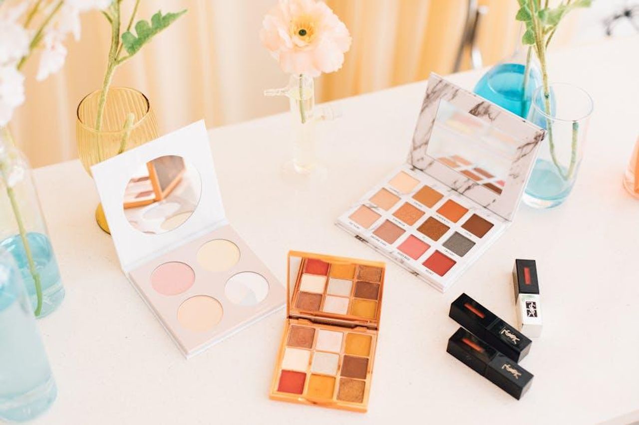 Il_lancio_di_Heather_Rae_Essentials_iVBFSYs1N2 - Confidenze24 Source: zhugewala - pexels - Aesthetic display of makeup palettes and lipsticks surrounded by flowers.