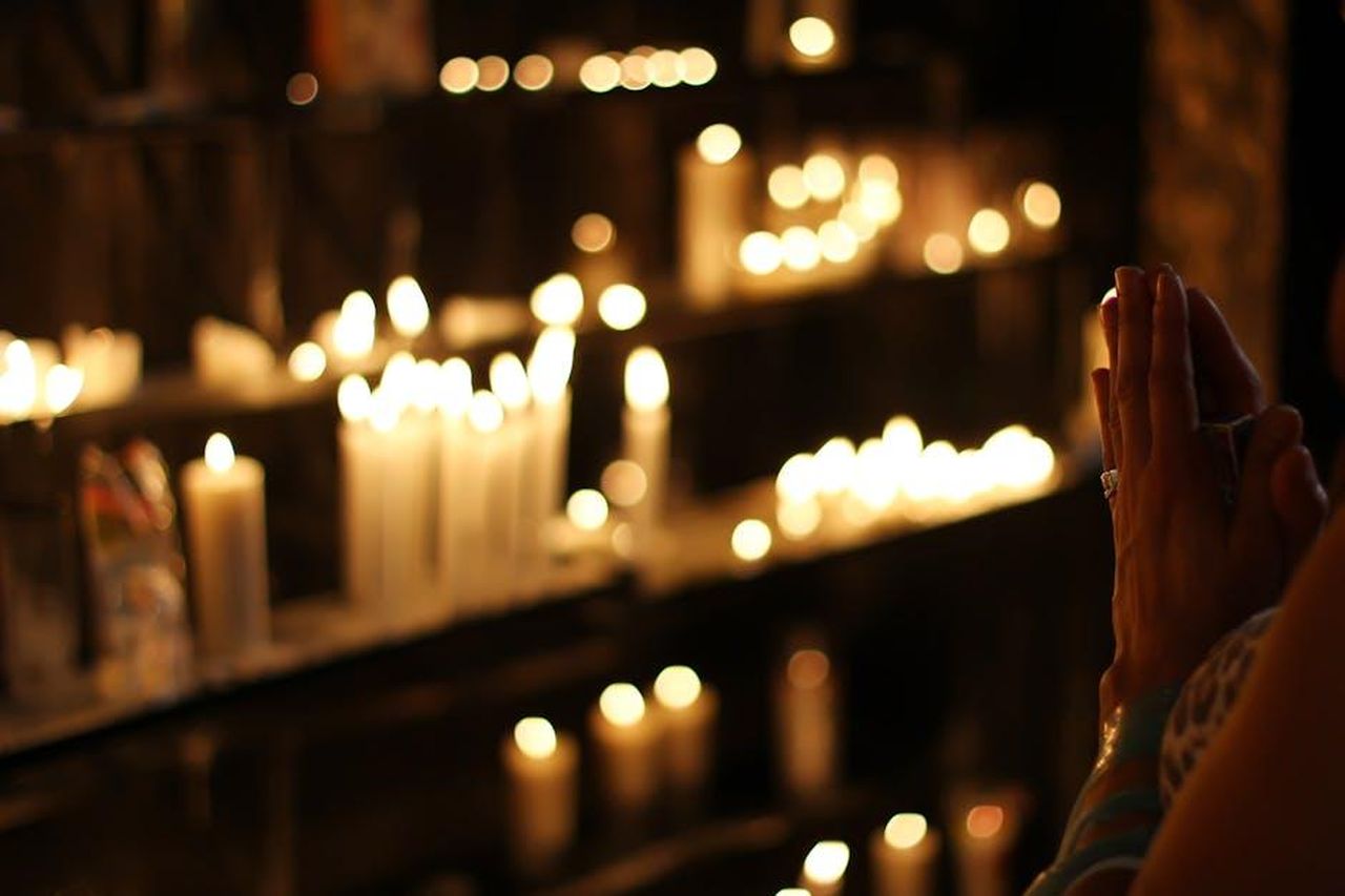 Il_legame_di_Gwen_con_Hallow_e_la_religione_DMPs1F1m1b - Confidenze24 Source: Rodolfo Clix - pexels - Hands clasped in prayer by candlelight in a church in São Paulo, Brazil, evoking a spiritual atmosphere.