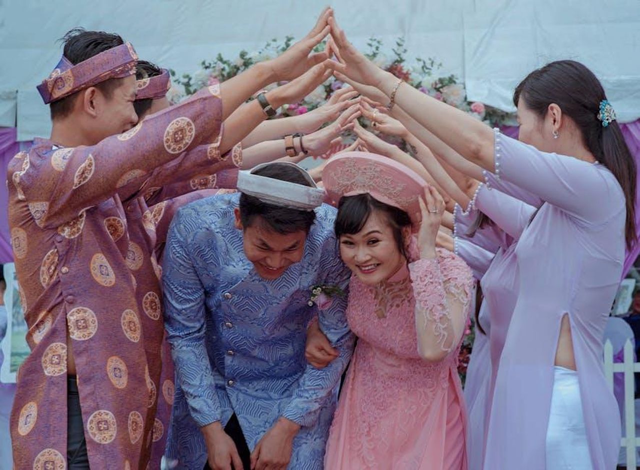 Il_matrimonio_di_Justin_e_Sofia_8Ra9UoHfz8 - Confidenze24 Source: Min An - pexels - Happy Vietnamese couple celebrates their wedding with friends in traditional attire outdoors.