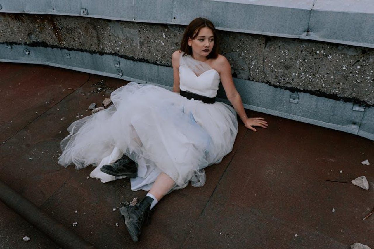 Il_matrimonio_di_Kim_Kardashian_con_Kris_Humphries_uznBYH6vTn - Confidenze24 Source: cottonbro studio - pexels - Bride in a wedding gown seated on urban rooftop, blending elegance with grit.