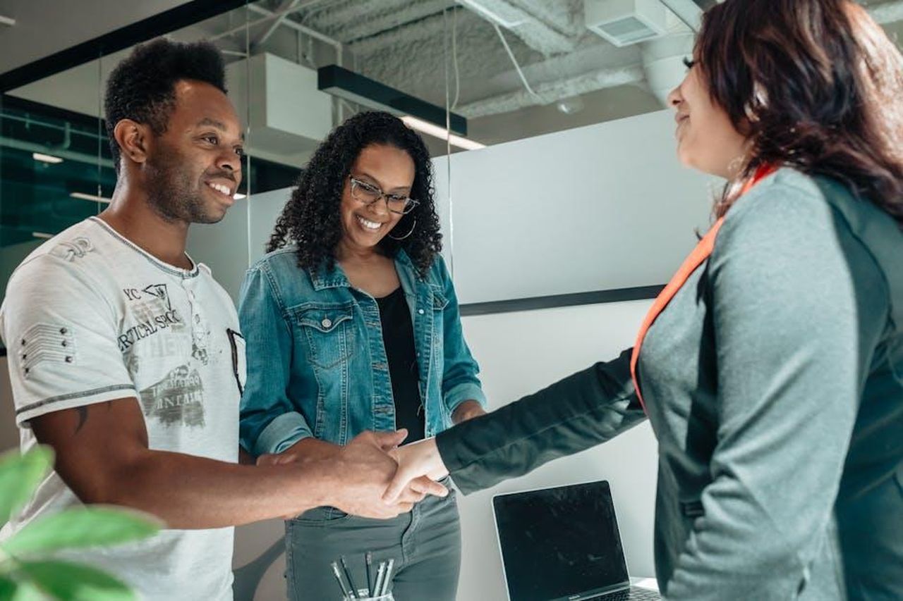 Il_messaggio_di_Sharna_Burgess_sulla_cogenitorialit_NbsLNpiTAW - Confidenze24 Source: Kindel Media - pexels - Smiling couple shaking hands with advisor in modern office.
