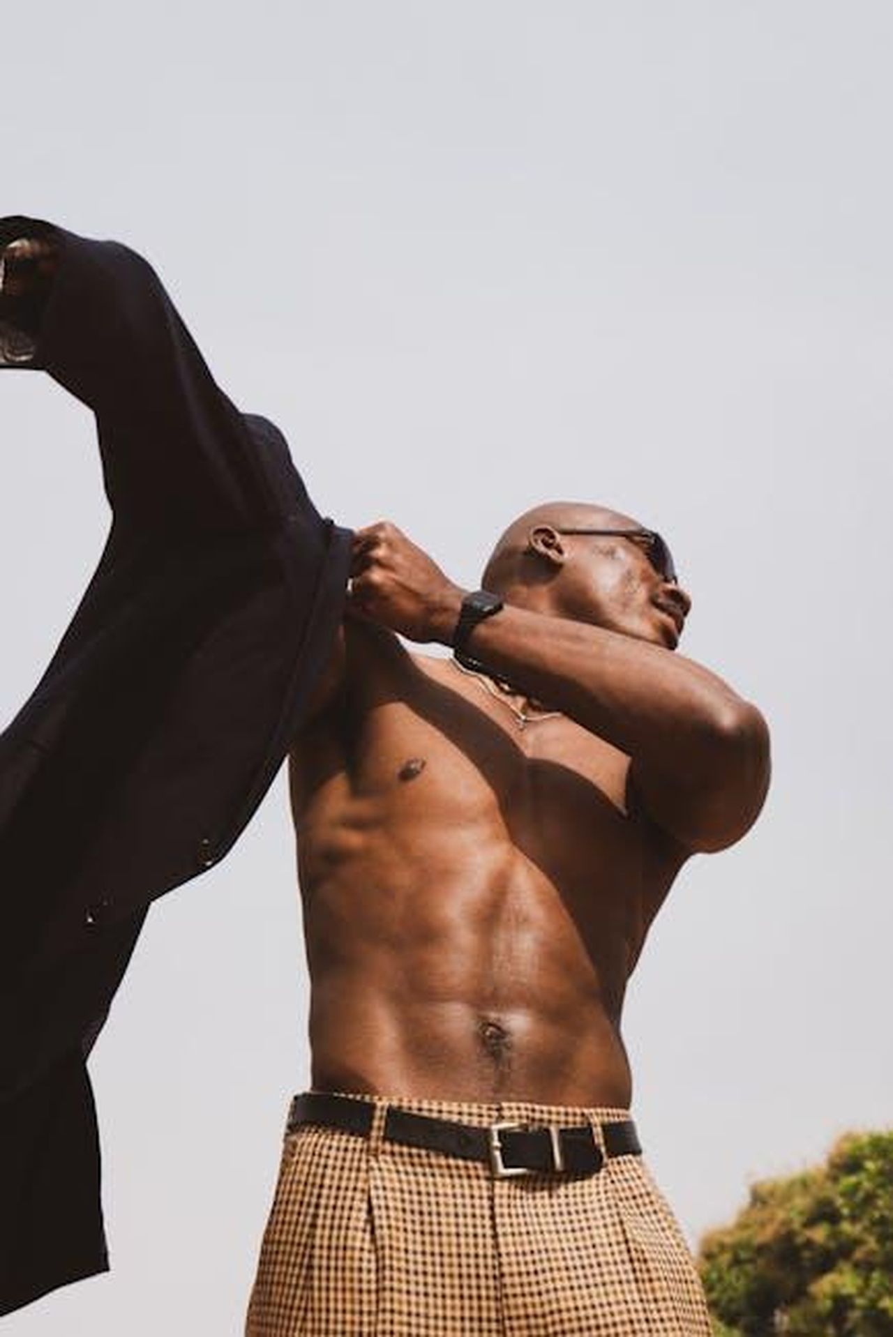 Il_nuovo_look_del_Principe_William_oH9U7pBcIG - Confidenze24 Source: Stephen Audu - pexels - Athletic man with sunglasses posing outdoors, showcasing strength and style in Lagos.