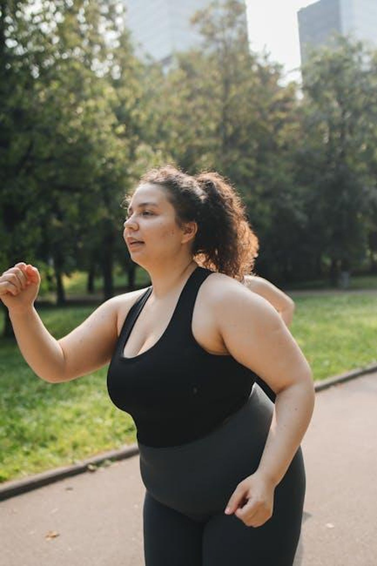 Il_percorso_di_perdita_di_peso_di_Josie_Gibson_KcHZa4vStE - Confidenze24 Source: Polina Tankilevitch - pexels - Confident plus-size woman running in a sunny park promoting active lifestyle and fitness.