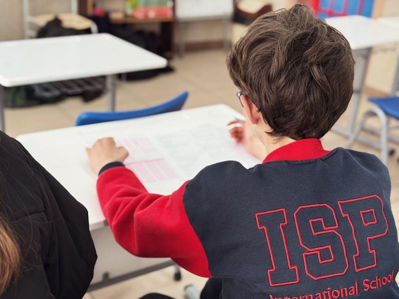 Il_piacere_di_leggere_insieme_ai_bambini_ho5PoutXKo - Confidenze24 Source: SNDRF . - pexels - A student engaged in learning at an international school desk.