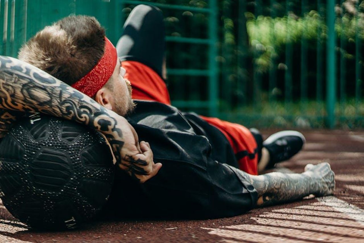Il_primo_tatuaggio_di_Vanna_White_MiMsneWUss - Confidenze24 Source: cottonbro studio - pexels - Tattooed man relaxes on basketball court with a ball, displaying athletic lifestyle.