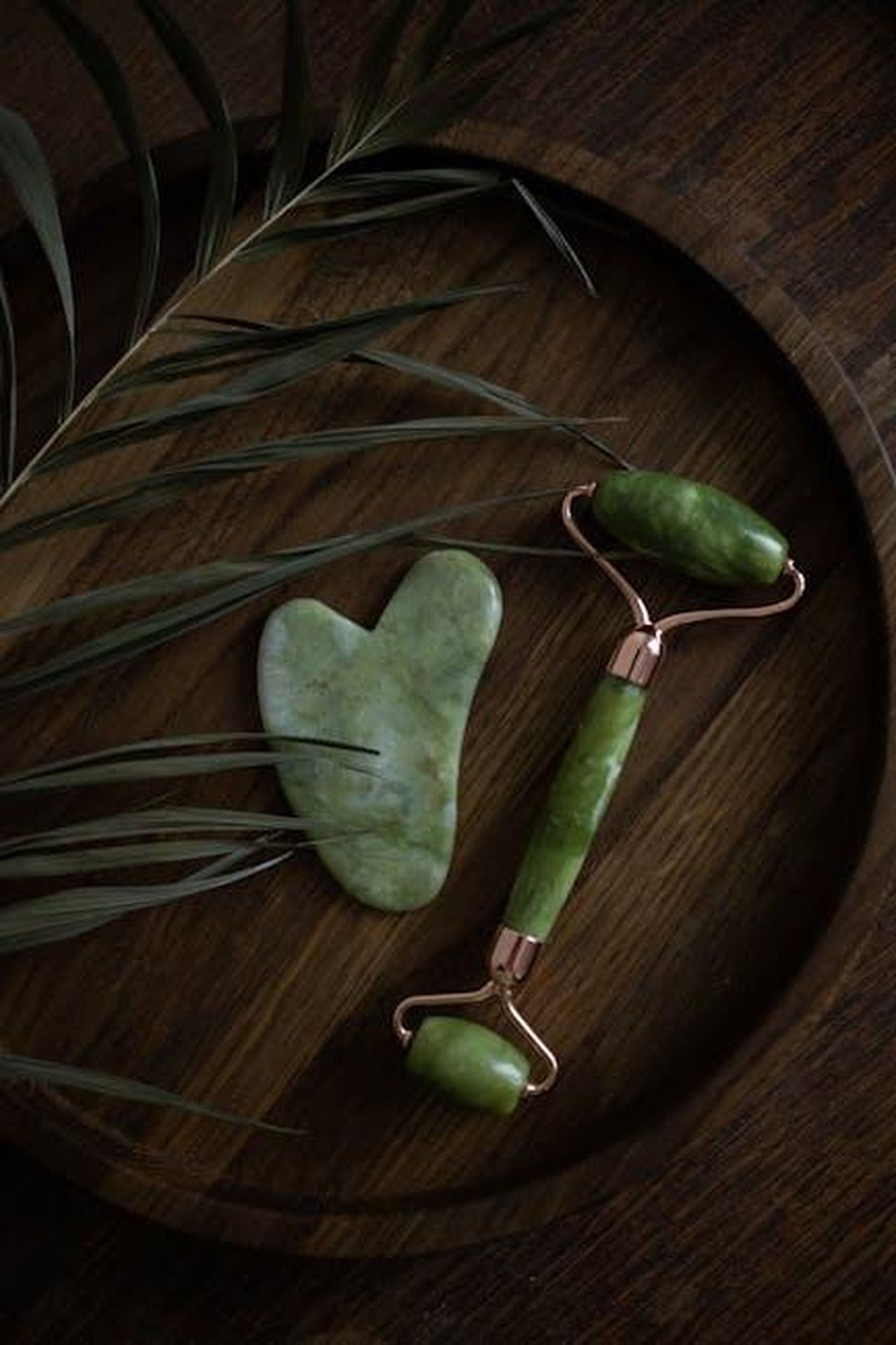 Il_progetto_di_legge_e_le_sue_implicazioni_cUa4nGIP8R - Confidenze24 Source: KATRIN BOLOVTSOVA - pexels - A jade roller and gua sha stone on a wooden tray with green leaves, perfect for skincare routines.