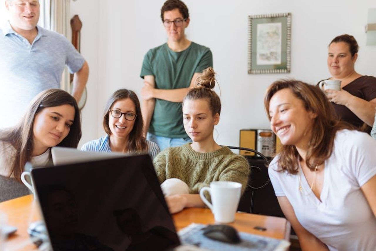 Il_rebranding_di_As_Ever_e_i_riferimenti_familiari_HMj7a3OVny - Confidenze24 Source: Fox - pexels - A diverse group of adults at work, enjoying a casual meeting indoors with focus and smiles.