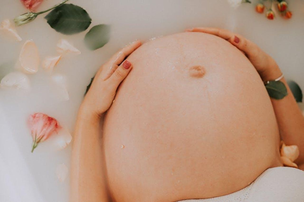 Il_riconoscimento_delle_madri_xUJxEAj1cS - Confidenze24 Source: lucas mendes - pexels - Pregnant woman relaxing in a soothing milk bath with flowers, embracing maternity.