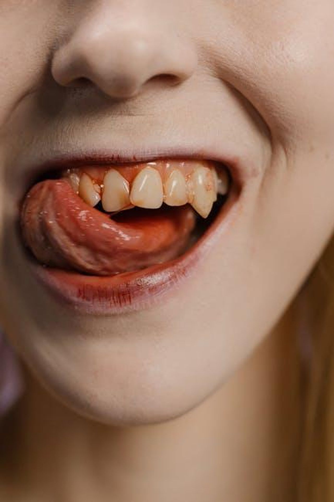 Il_ritorno_di_Buffy_un_reboot_in_arrivo_0K9H1WCuyx - Confidenze24 Source: cottonbro studio - pexels - Detailed shot focusing on a mouth with visible fangs and tongue, evoking a vampire aesthetic.