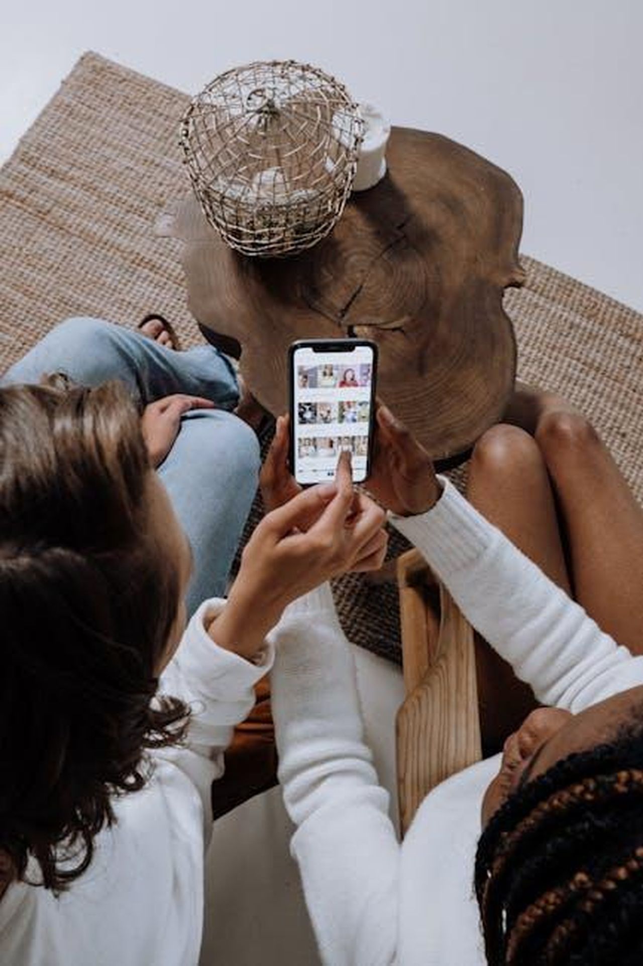 Il_ritorno_di_Taylor_Swift_sui_social_media_XwgV8fusIL - Confidenze24 Source: cottonbro studio - pexels - Two people looking at social media on a smartphone at a wooden table.