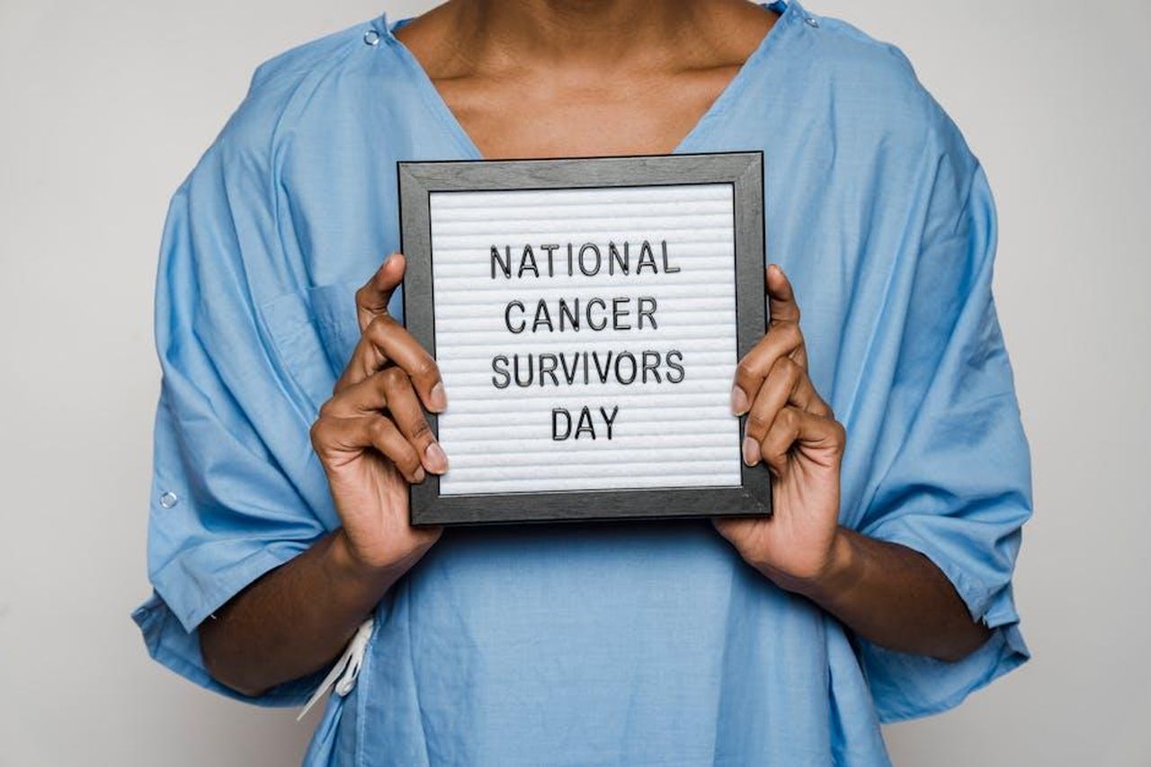 Il_ritorno_di_Tina_in_Corrie_vXPo8oulwr - Confidenze24 Source: Klaus Nielsen - pexels - A person in a blue gown holds a sign marking National Cancer Survivors Day.