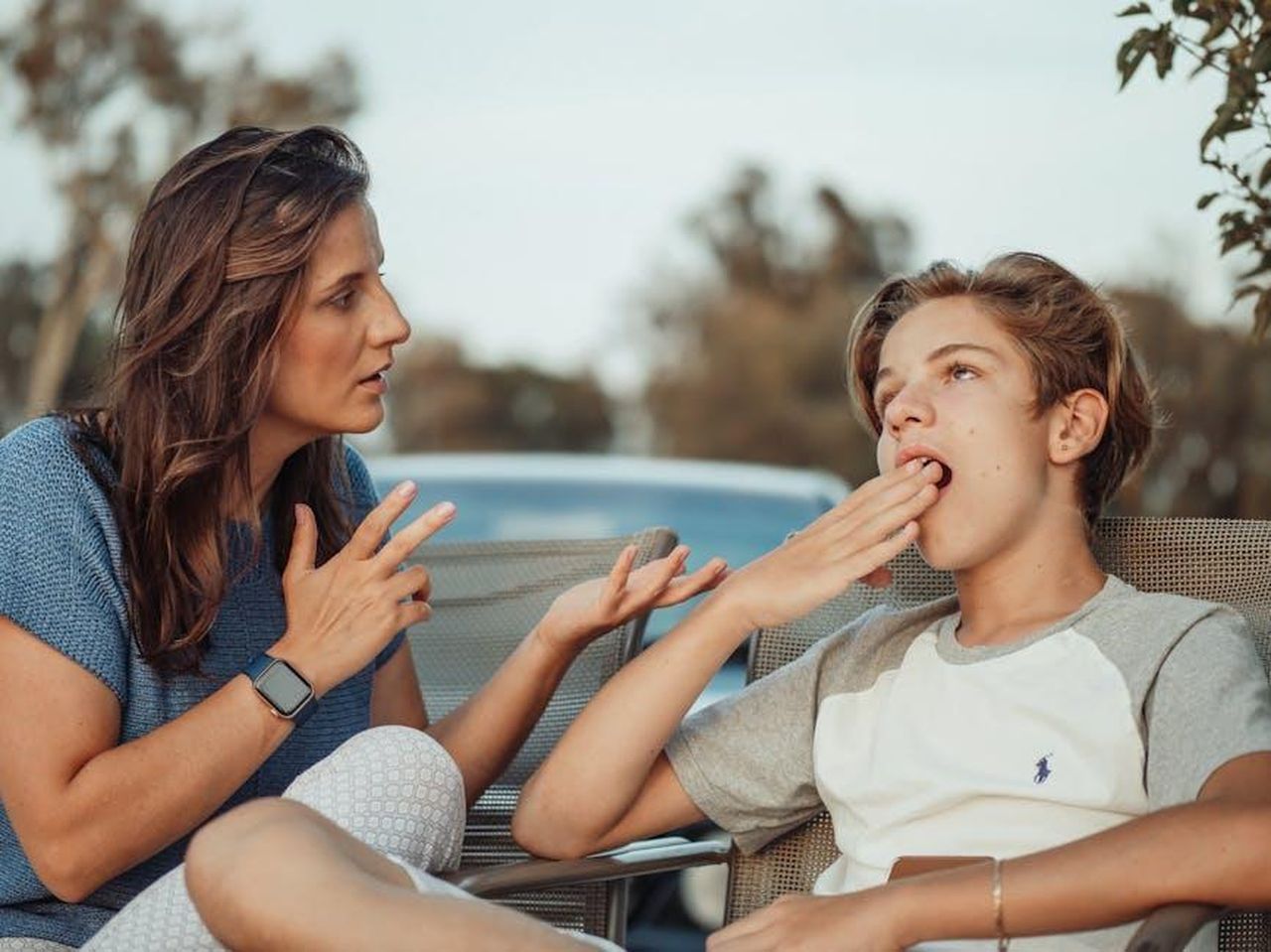 Il_ruolo_dei_genitori_nella_gestione_del_tempo_di_schermo_N7XEtclLM4 - Confidenze24 Source: Kindel Media - pexels - A mother and her teenage son are having a conversation outdoors. The son appears disinterested.