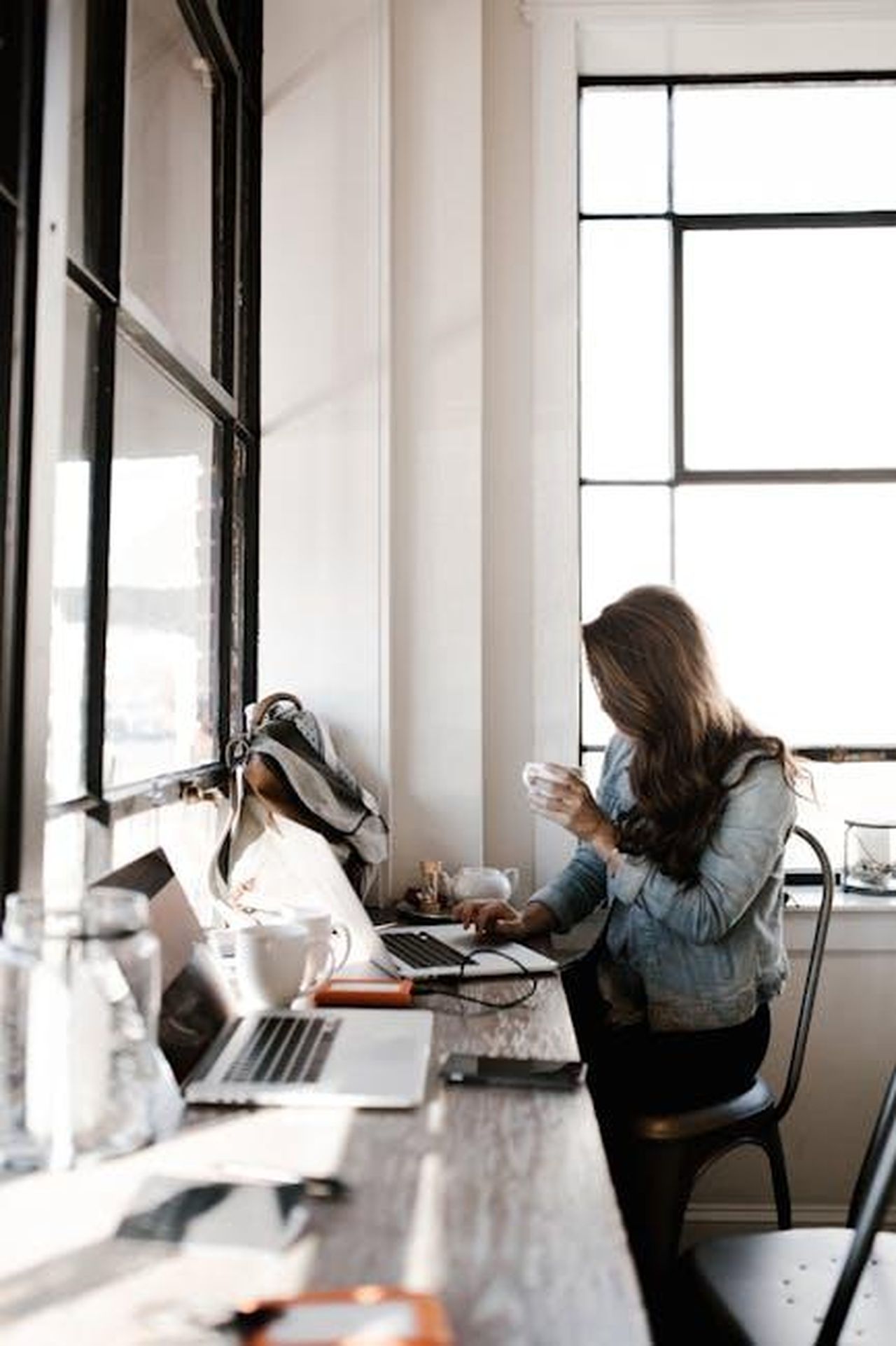 Il_ruolo_di_Delta_in_Designing_Women_G6Asj6s4ga - Confidenze24 Source: Andrew Neel - pexels - A young woman working on her laptop, sipping coffee in a bright café setting.