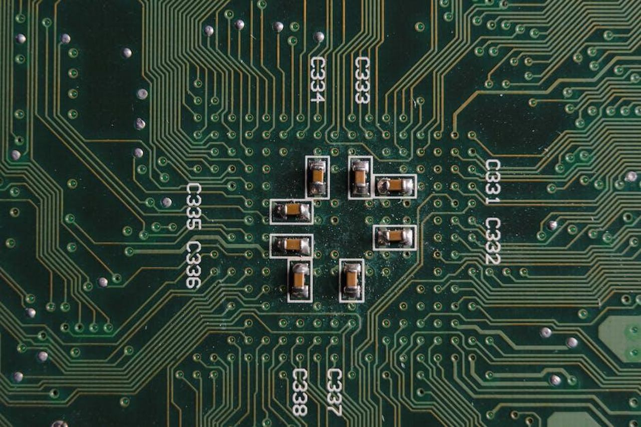 Il_sistema__rotto_Ju629YNyt4 - Confidenze24 Source: Tima Miroshnichenko - pexels - Explore the intricate design and components on a green circuit board with capacitors and pathways.