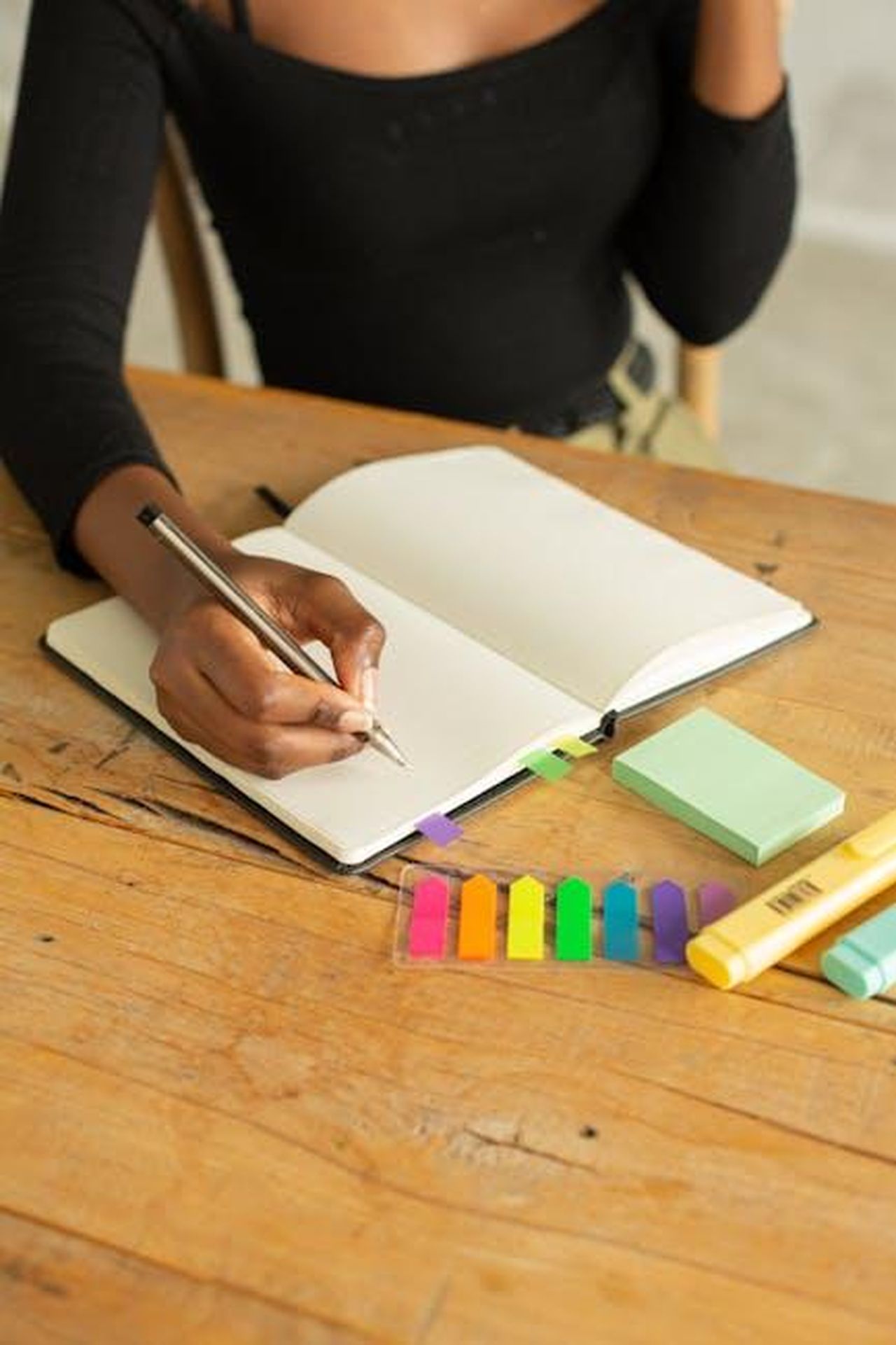 Il_successo_di_Meghan_e_il_confronto_con_Harry_BxZ9CrJrB1 - Confidenze24 Source: Monstera Production - pexels - Crop unrecognizable ethnic female sitting at wooden table and taking notes on white blank page of notepad with pencil and markers