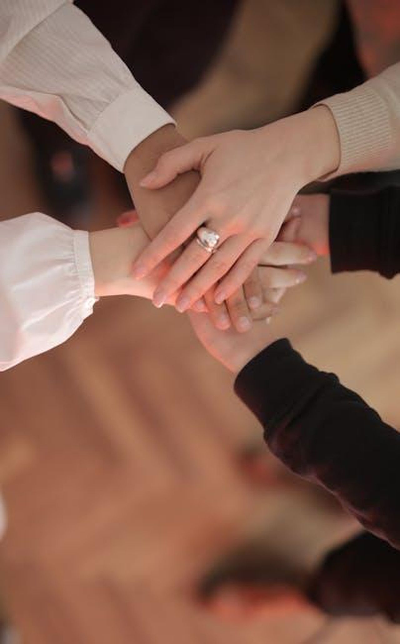 Il_supporto_dei_fan_per_Ginger_Zee_kLrGNe5gyL - Confidenze24 Source: Andrea Piacquadio - pexels - Top view of faceless friends in different clothes stacking hands together while standing on wooden floor indoor on sunny day