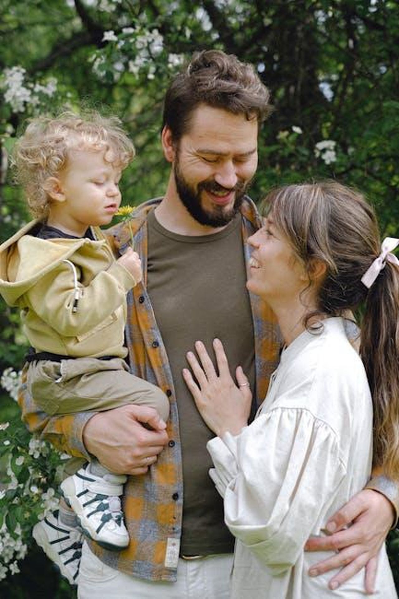 Il_supporto_dei_genitori_uMkZ6rQRGR - Confidenze24 Source: Anna Shvets - pexels - A joyful family moment captured in a Spring garden, featuring a child with parents embracing.