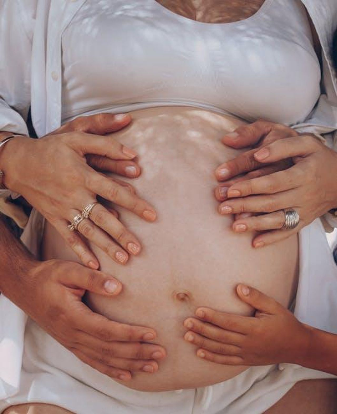 Il_supporto_del_marito_e_la_sua_esperienza_Xy3zPmKiLD - Confidenze24 Source: Elias Suarez - pexels - Hands of family members lovingly touching a pregnant belly outdoors, symbolizing unity and new beginnings.