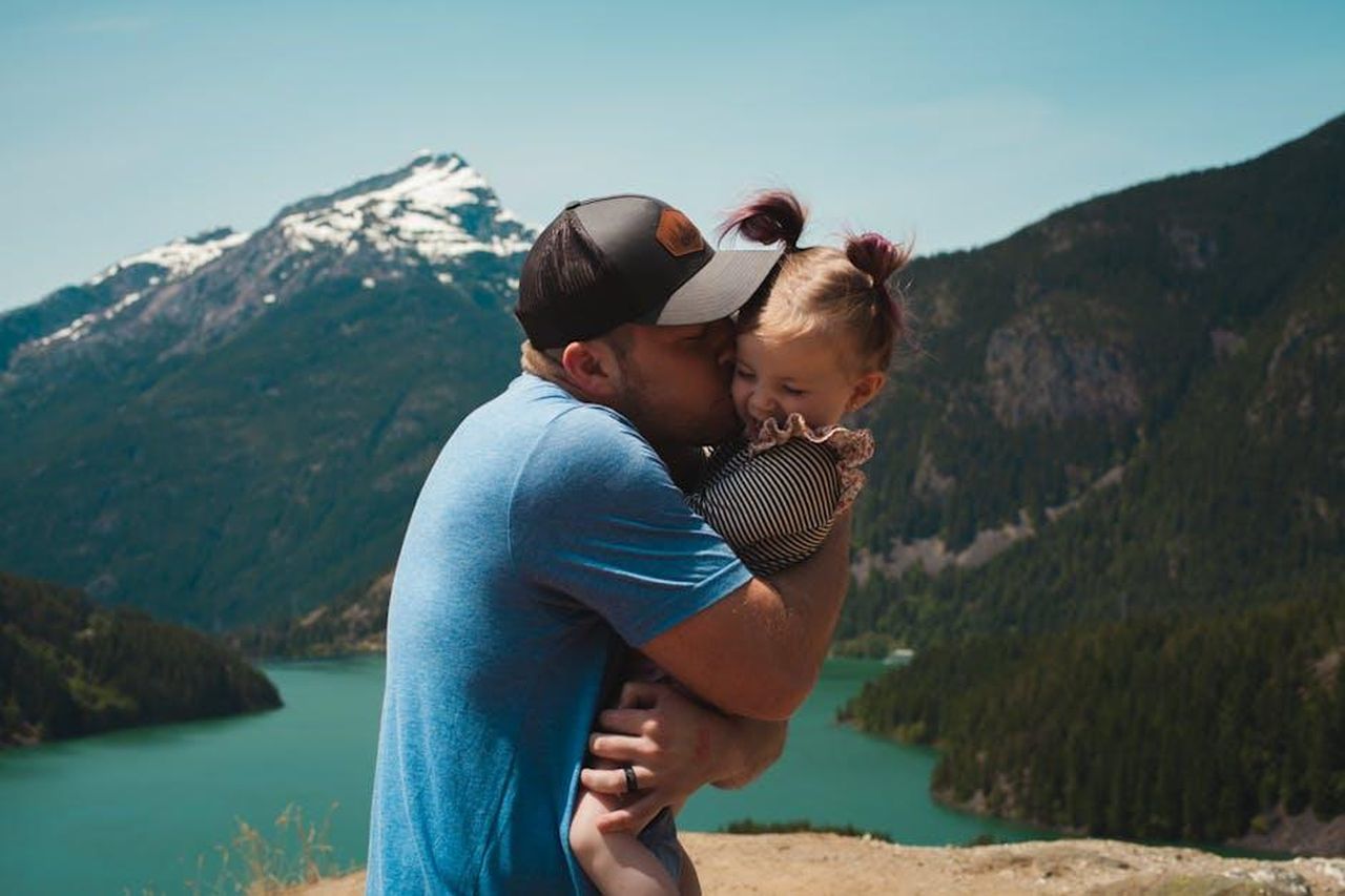 Il_supporto_di_Dwyane_Wade_e_la_reazione_dei_fan_snpiBNgfGW - Confidenze24 Source: Josh Willink - pexels - A heartwarming scene of a father hugging his daughter in a stunning mountain landscape.