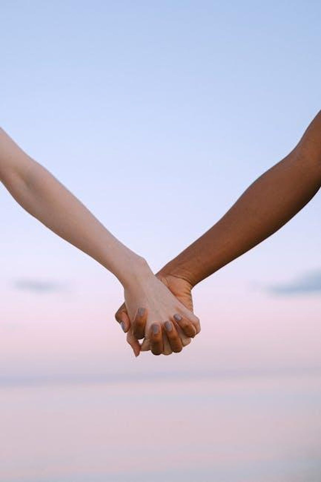 Il_supporto_di_Erin_Napier_C9DTnm70ji - Confidenze24 Source: Anna Shvets - pexels - Closeup of multiracial hands holding, symbolizing unity and equality against a serene sky.