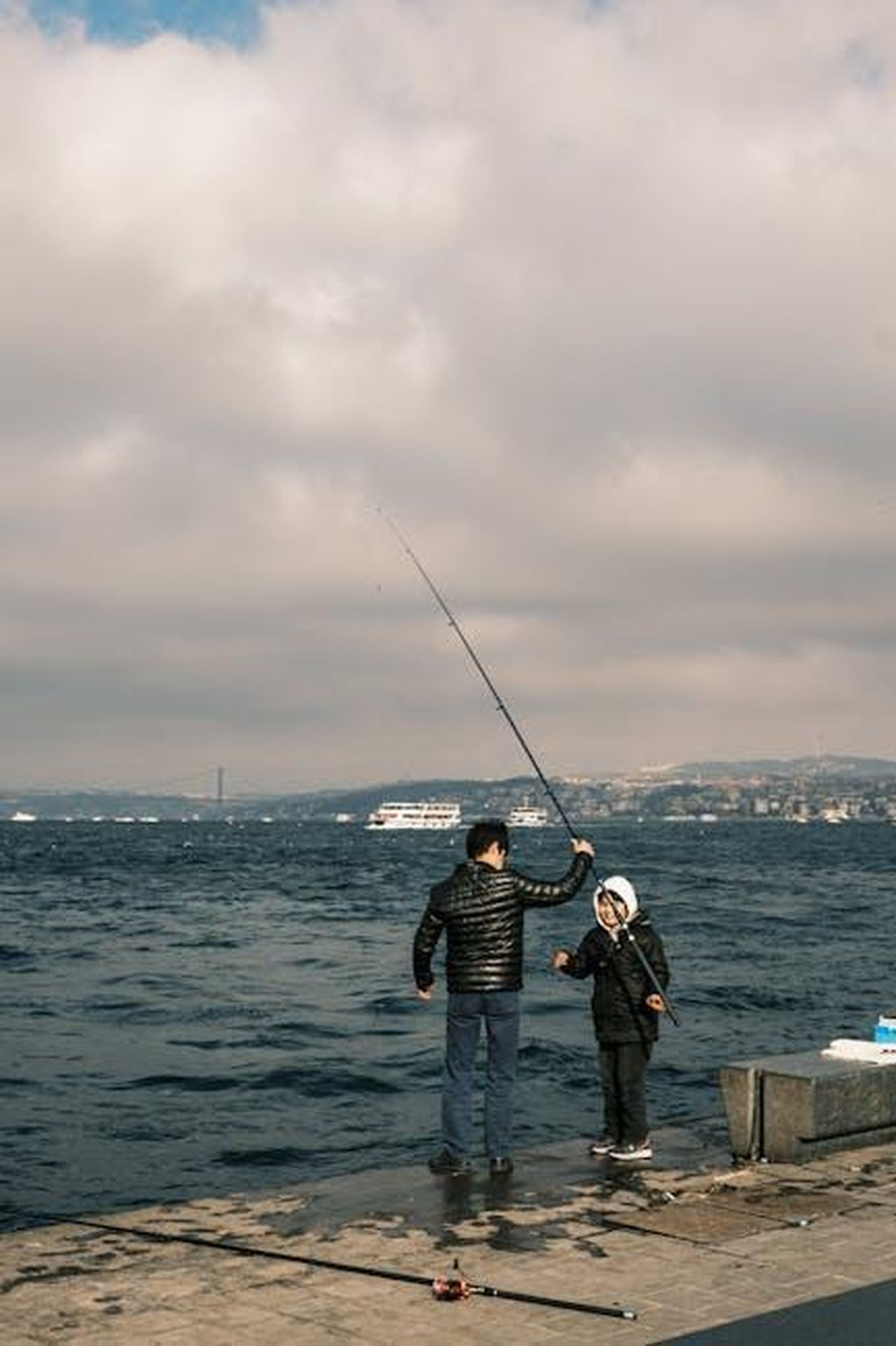 Il_supporto_di_Tina_a_Julez_il_nipote_maggiore_OUxES7NxEI - Confidenze24 Source: Murat Ak - pexels - A father and child enjoy fishing by the sea, capturing a bonding moment.