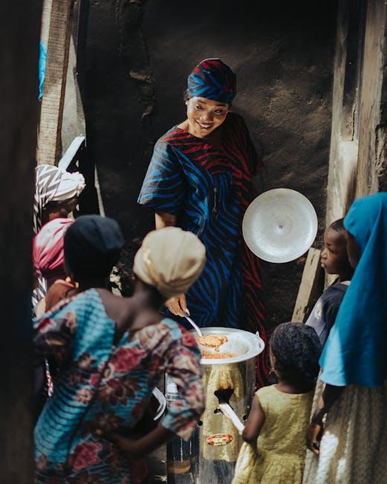 Il_tema_preferito_di_conversazione_di_Meghan_CTtWuEYThD - Confidenze24 Source: King Shooter - pexels - Woman selling goods at an outdoor market surrounded by customers.
