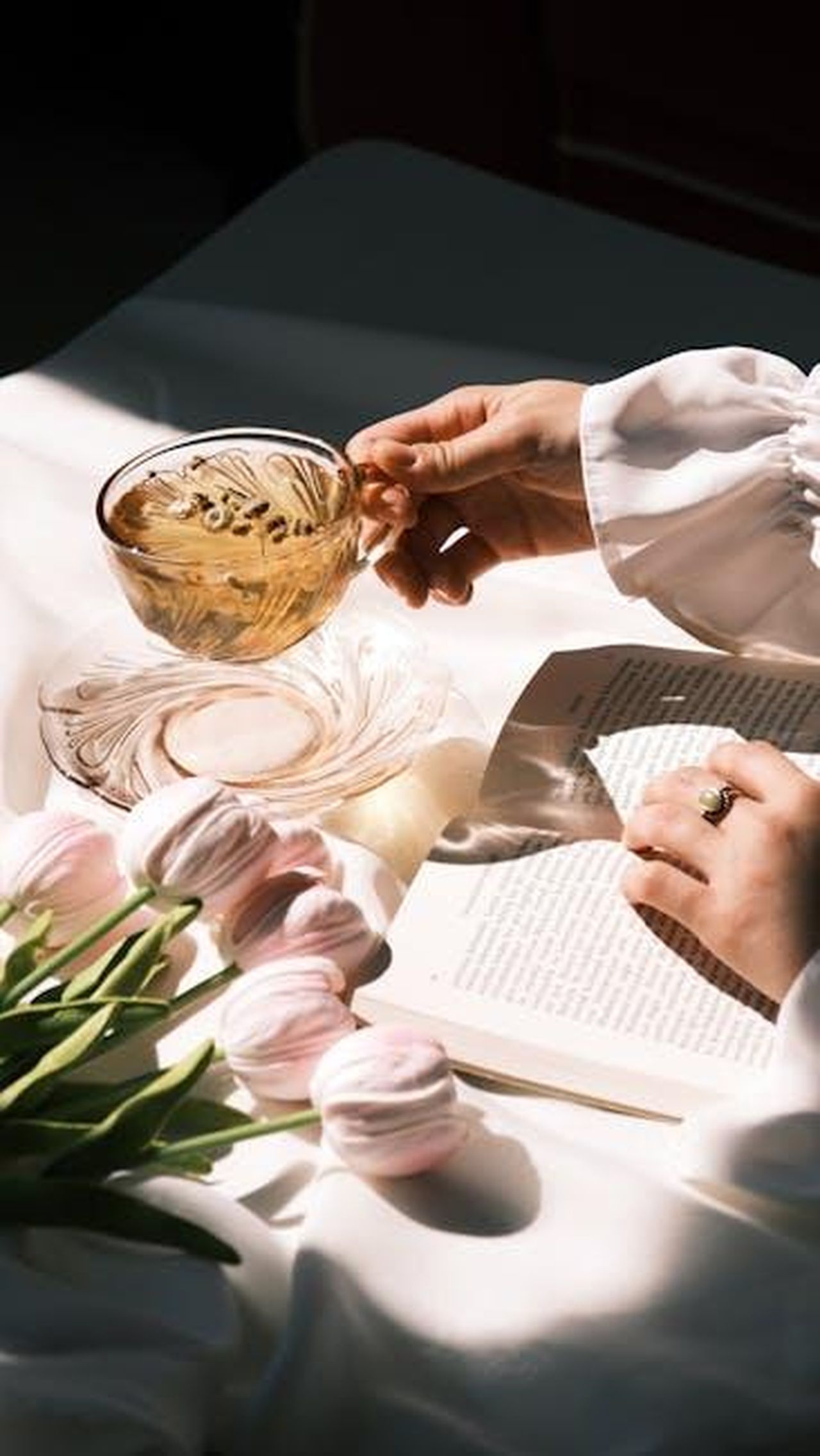 Il_tempo_di_Georgia_LvJ2R06jKA - Confidenze24 Source: Rahime Gül - pexels - Elegant tea time setting with tulips, macarons, and a book in soft light.