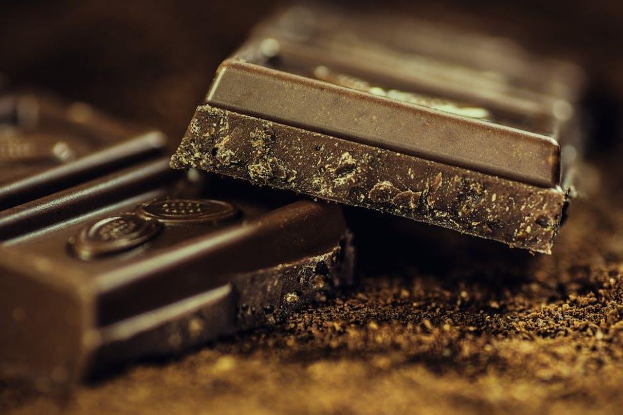 Il_tocco_finale_cioccolato_fondente_WsQSCsxr3O - Confidenze24 Source: Pixabay - pexels - Macro shot of rich dark chocolate bars sprinkled with cocoa powder, highlighting texture and indulgence.