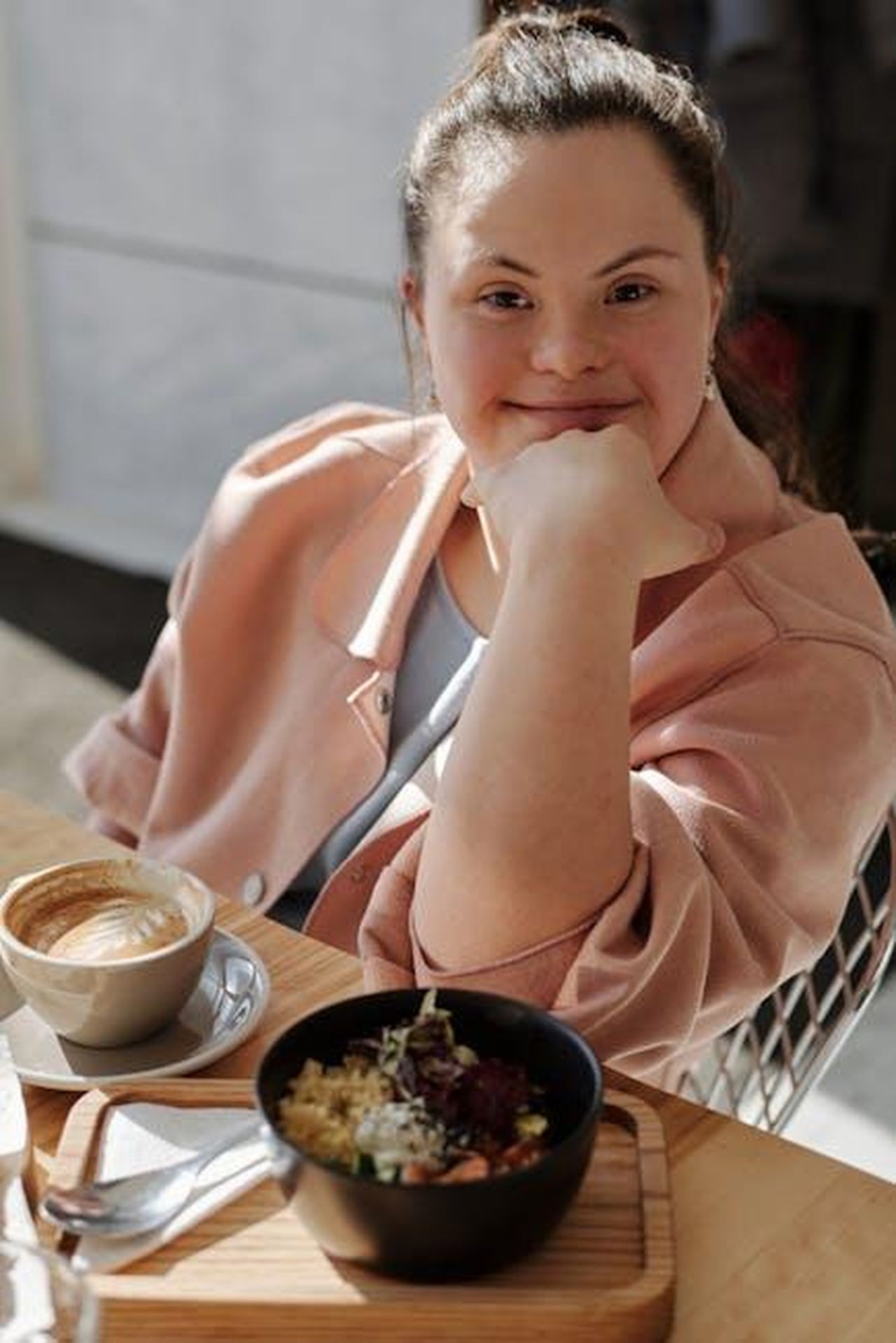 Il_tributo_di_Jessica_Biel_per_la_Giornata_Mondiale_della_Sindrome_di_Down_QQ7VoHaWKR - Confidenze24 Source: Cliff Booth - pexels - Smiling young woman with down syndrome enjoying breakfast and coffee at a café.