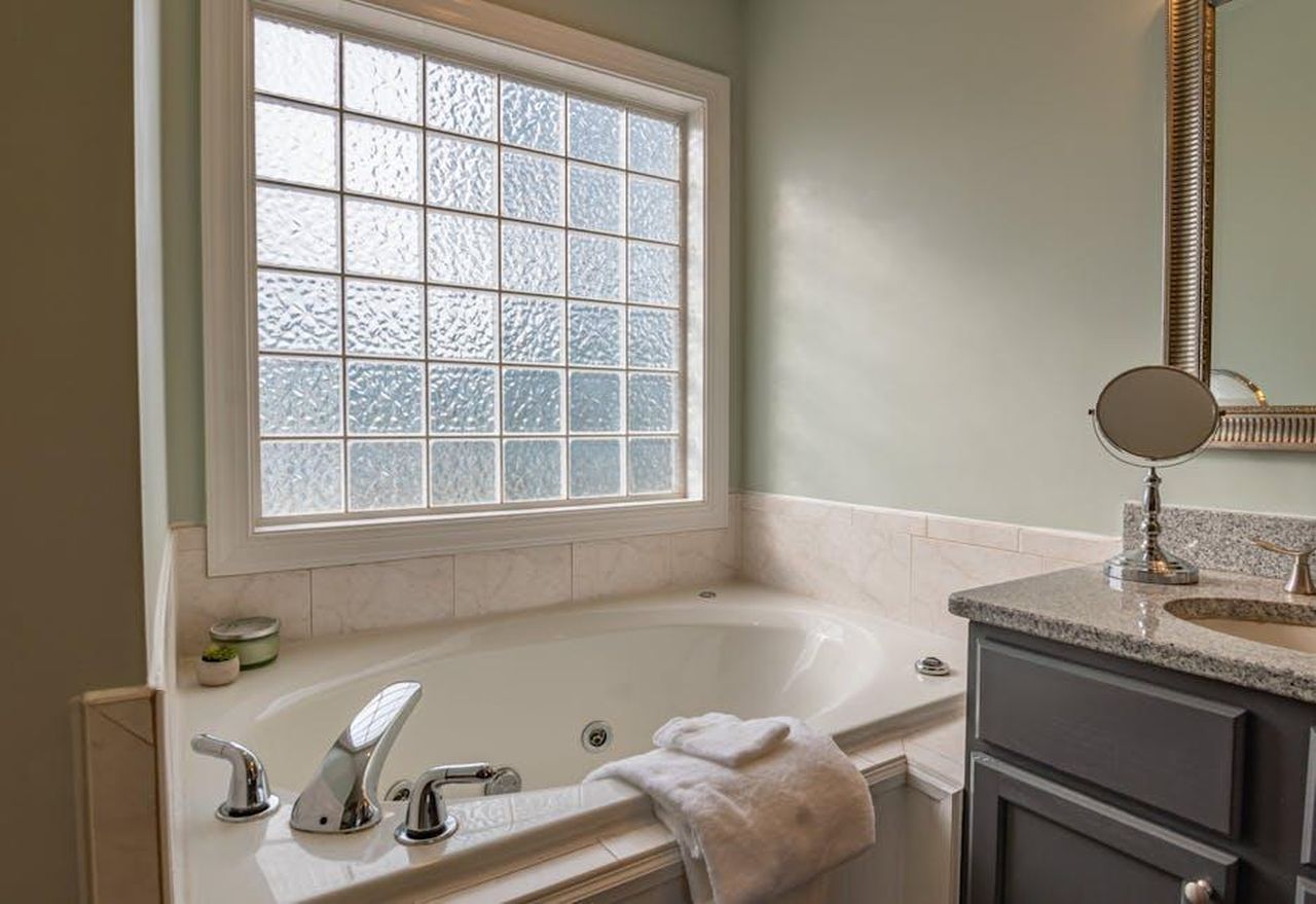 Il_valore_economico_del_Duchy_di_Cornwall_wKfokHS0pI - Confidenze24 Source: Curtis Adams - pexels - Stylish modern bathroom featuring a luxury bathtub, sleek sink, and large window. Perfect for relaxation.