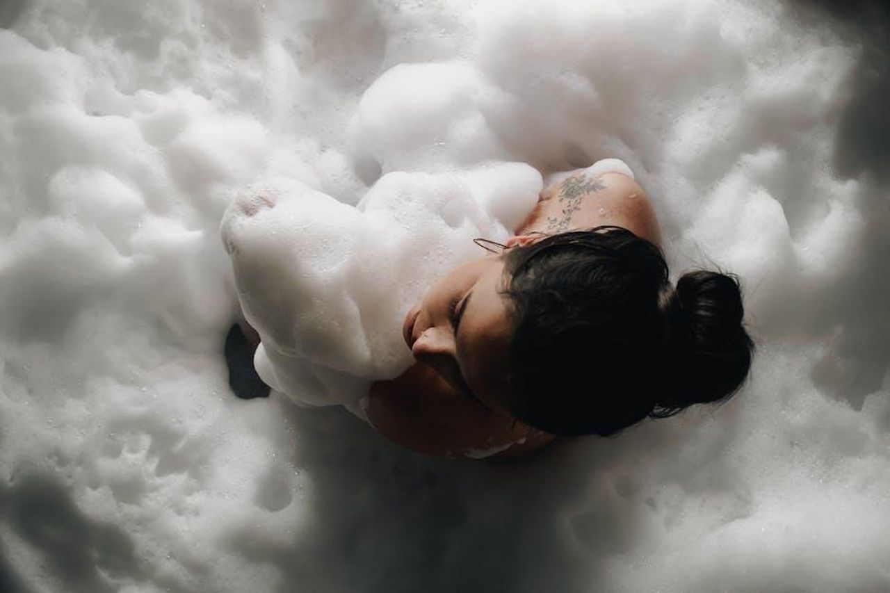Imposta_latmosfera_A35Zc5wKF8 - Confidenze24 Source: Produtora Midtrack - pexels - Top view of a woman relaxing in a foamy bathtub, embracing tranquility.